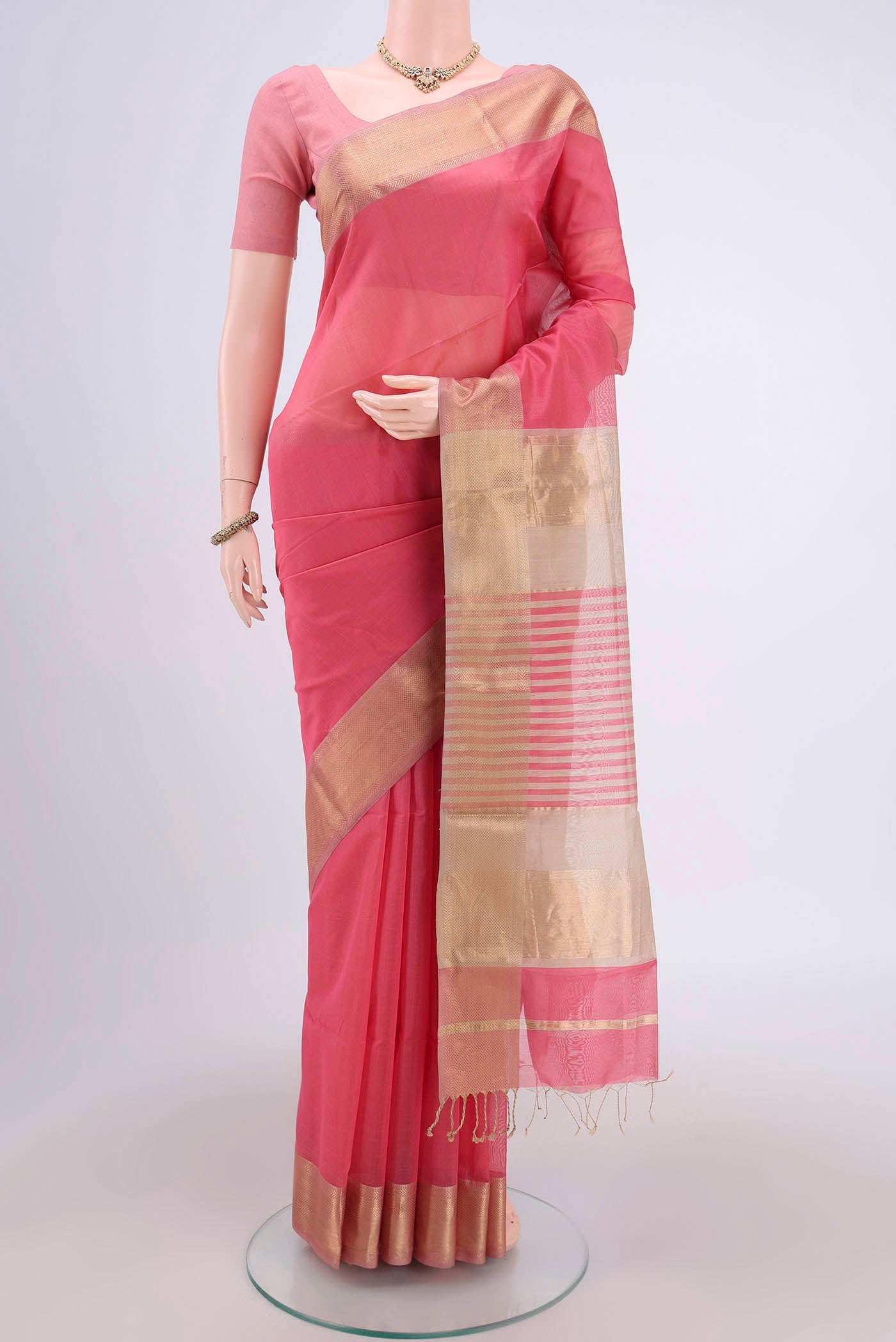 Peach Maheshwari Silk Cotton Saree with Plain Body and Zari Border.  displayed on a mannequin