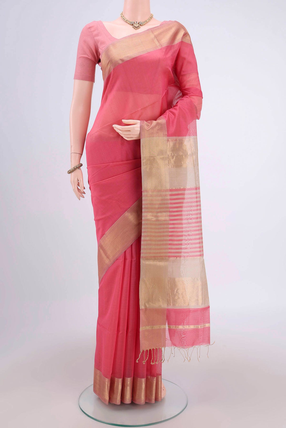 Peach Maheshwari Silk Cotton Saree with Plain Body and Zari Border.  displayed on a mannequin
