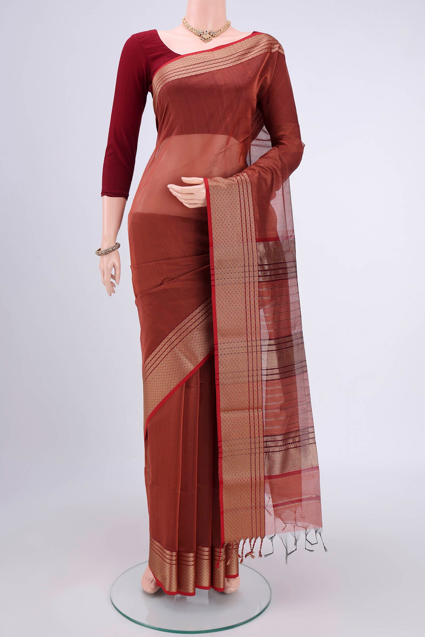 Brown Maheshwari Silk Cotton Saree with Plain Body and Zari Border.  displayed on a mannequin
