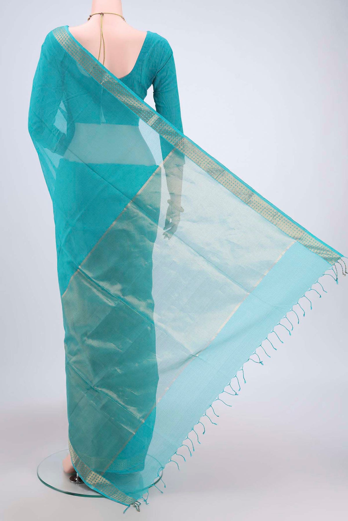 Flat view of Turquoise Maheshwari Silk Cotton Saree with Plain Body and Zari Border. 