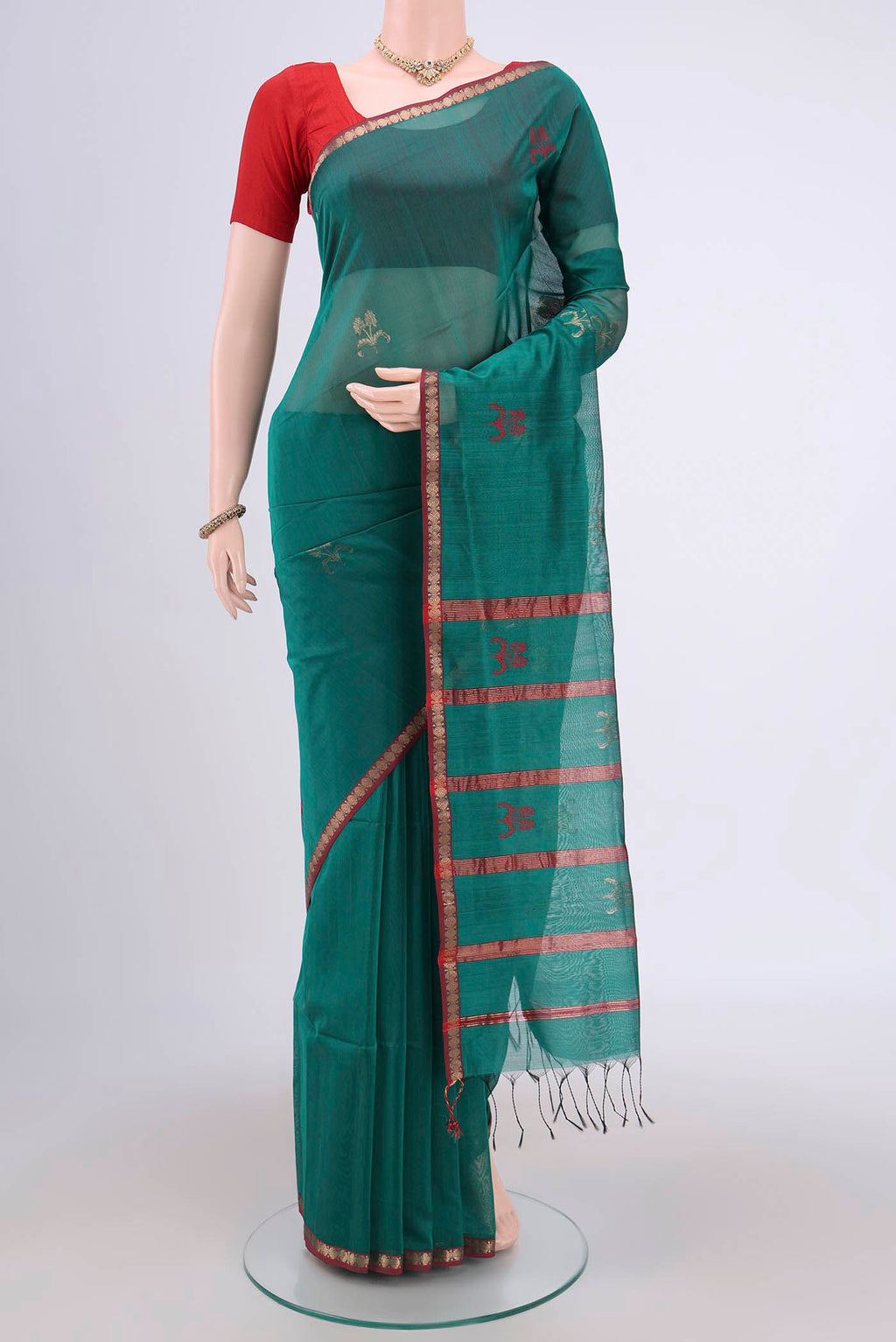 Sea Green Maheshwari Silk Cotton Saree with Zari And Thread Butta on the body and Zari Border.  displayed on a mannequin