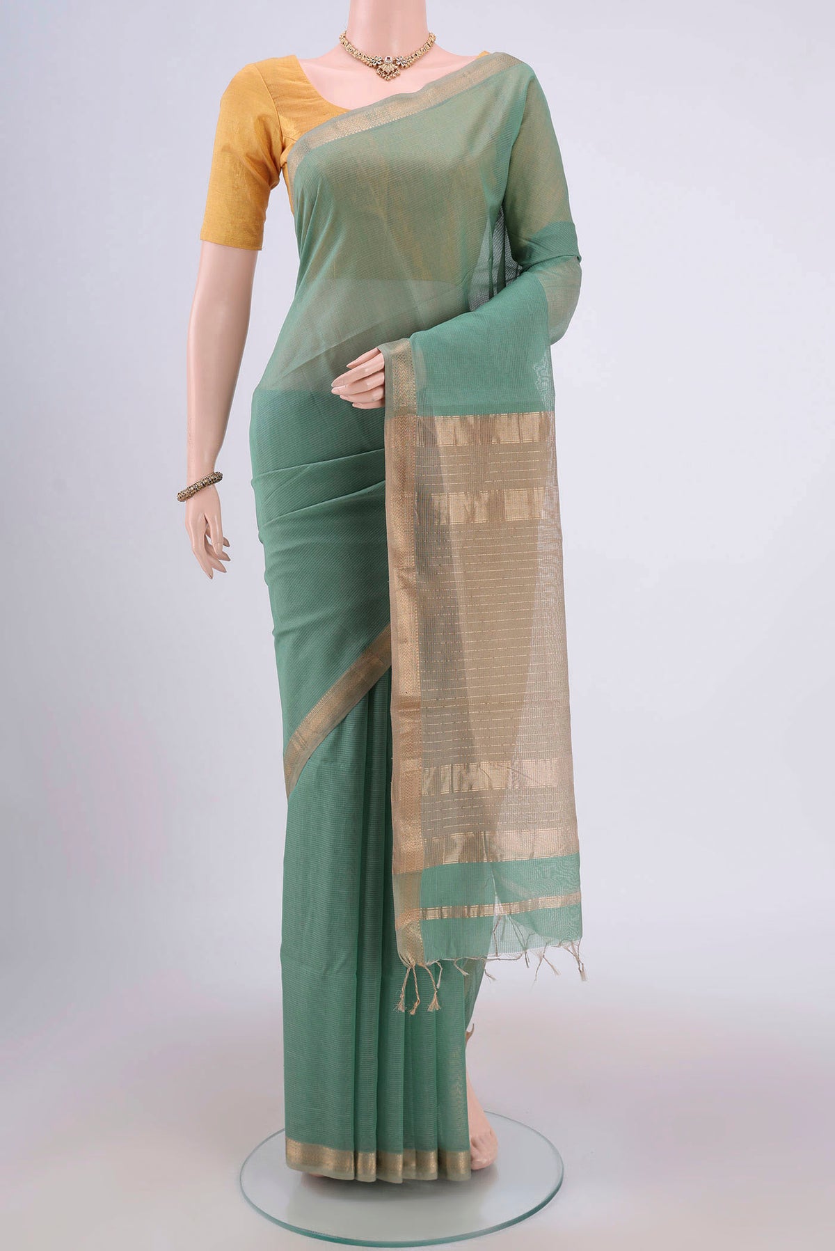 Sage Green Maheshwari Silk Cotton Saree with Stripes on the body and Zari Border.  displayed on a mannequin