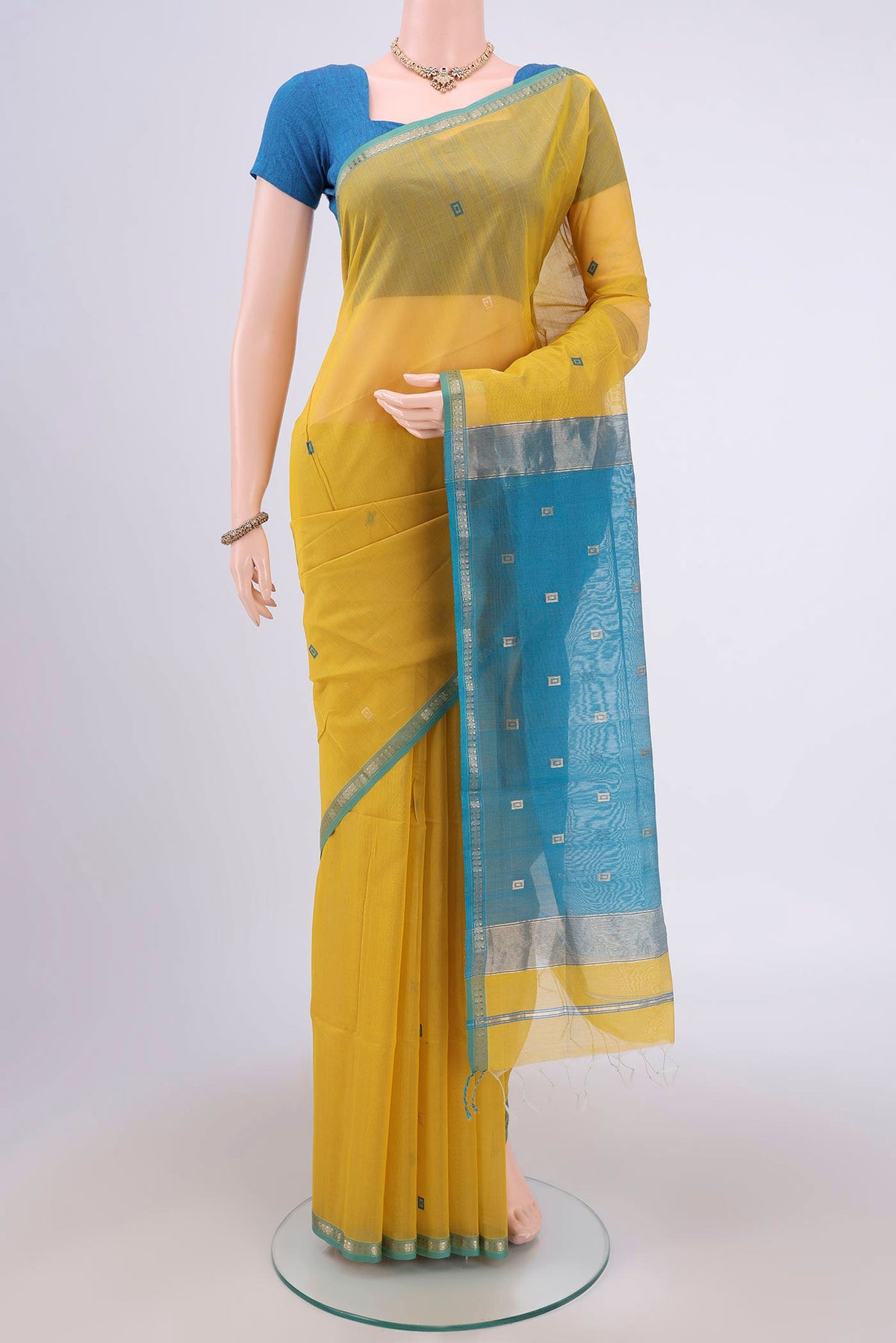 Lemon Yellow Maheshwari Silk Cotton Saree with Zari And Thread Butta on the body and Zari Border.  displayed on a mannequin