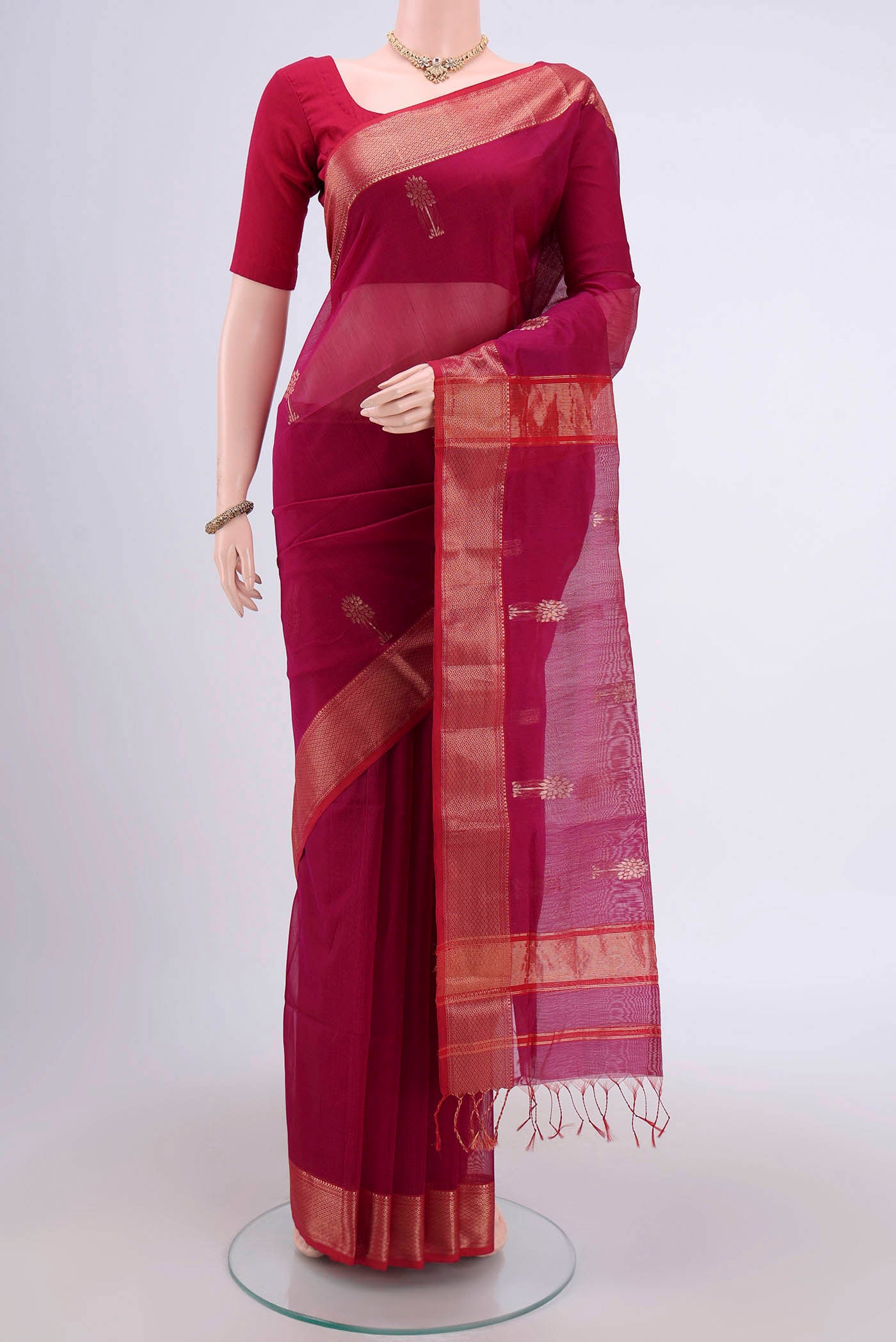 Magenta Maheshwari Silk Cotton Saree with Stripes on the body and Zari Border.  displayed on a mannequin