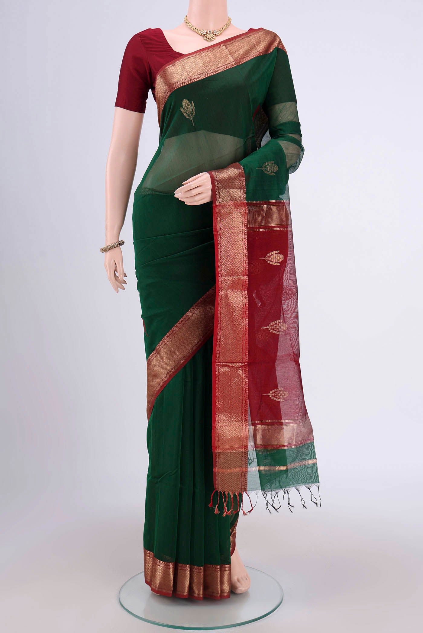 Bottle Green Maheshwari Silk Cotton Saree with Stripes on the body and Zari Border.  displayed on a mannequin