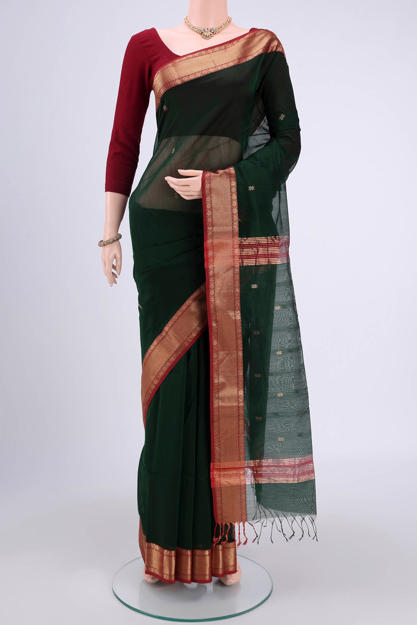 Bottle Green Maheshwari Silk Cotton Saree with Plain Body and Zari Border.  displayed on a mannequin