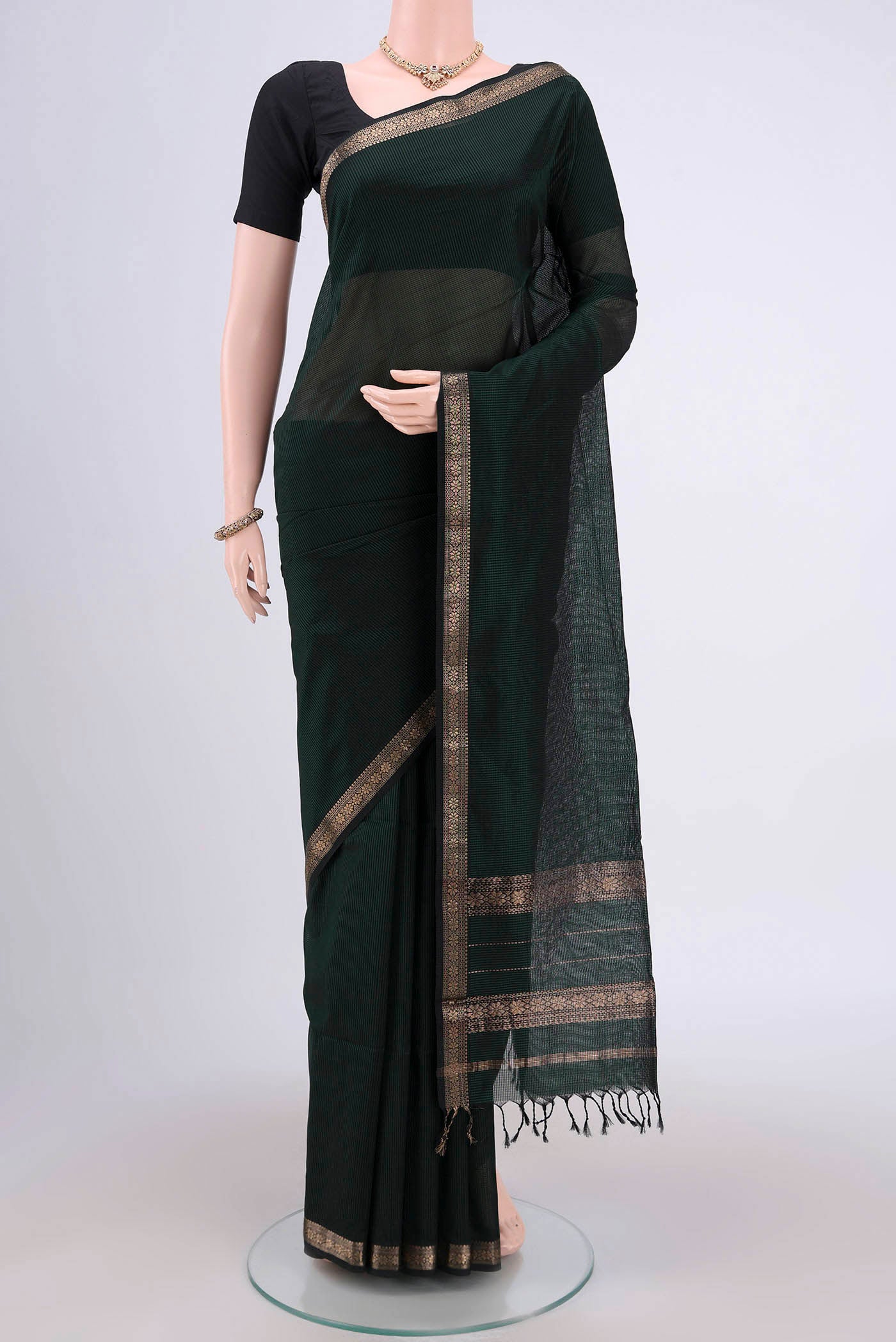 Bottle Green Maheshwari Silk Cotton Saree with Plain Body and Zari Border.  displayed on a mannequin