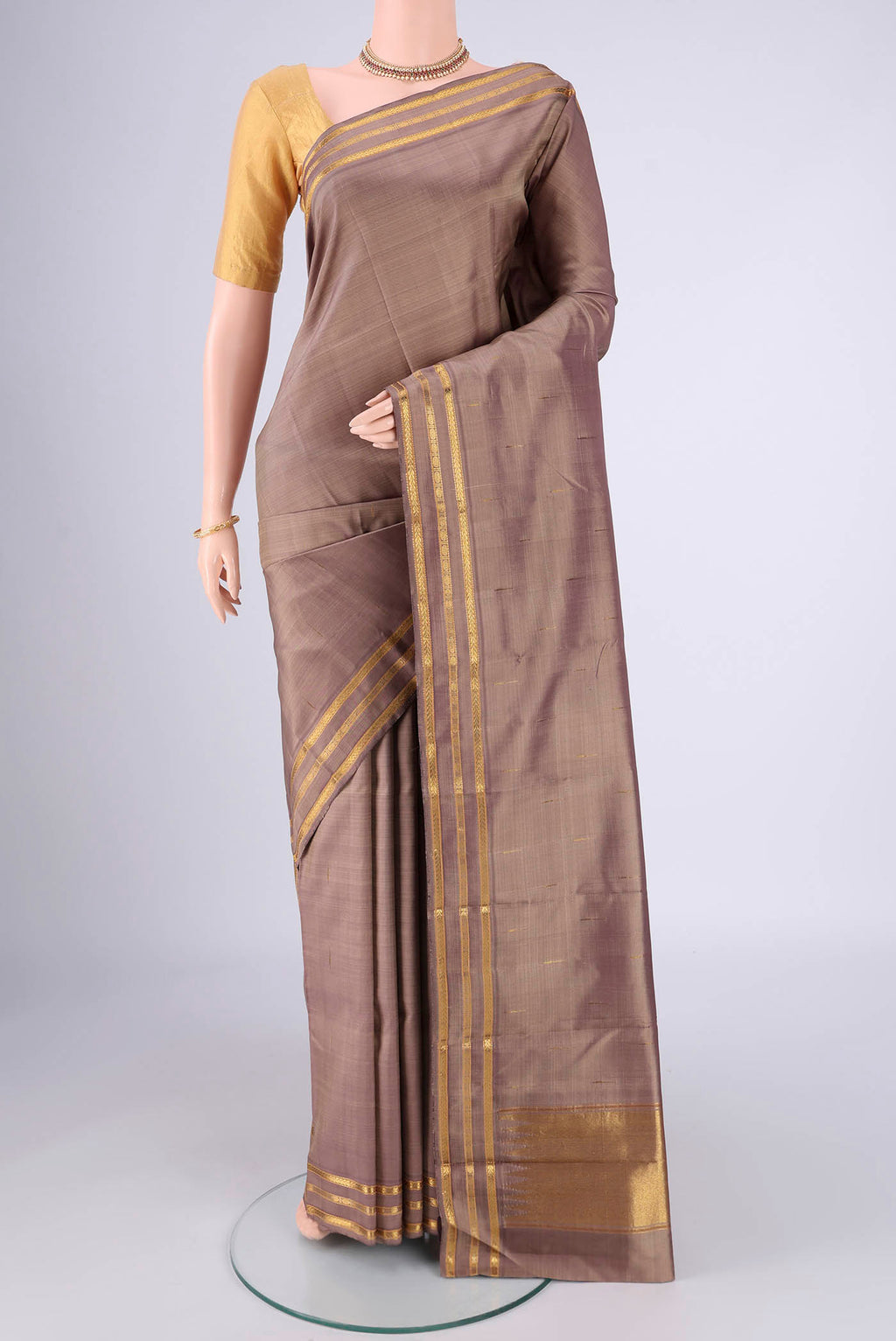 Brown Kanchipuram Silk Saree with Plain Body and Zari Border.  displayed on a mannequin