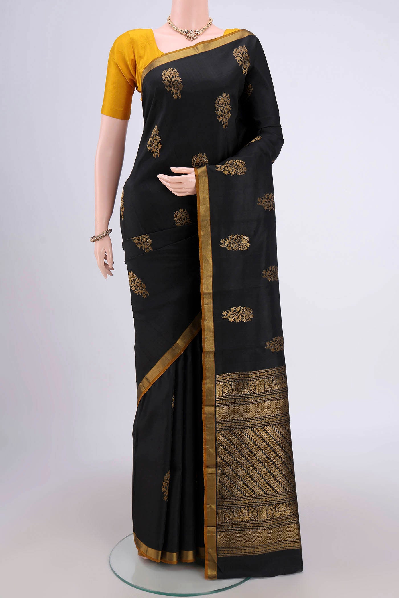 Black Dual Tone Kanchipuram Silk Saree with Zari Butta on the body and Zari Border.  displayed on a mannequin