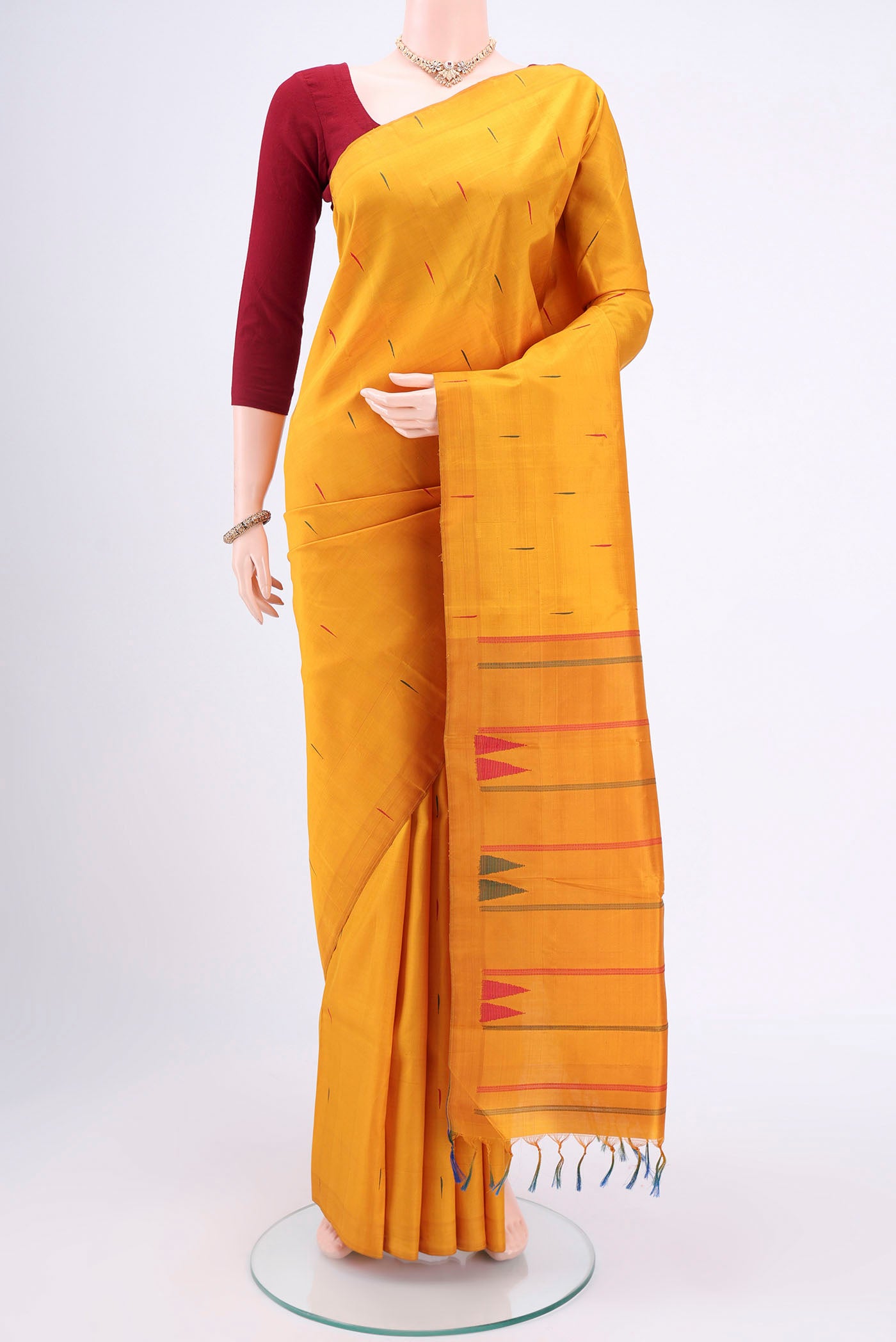 Mustard Kanchipuram Silk Saree with Thread Butta on the body and Plain Border.  displayed on a mannequin