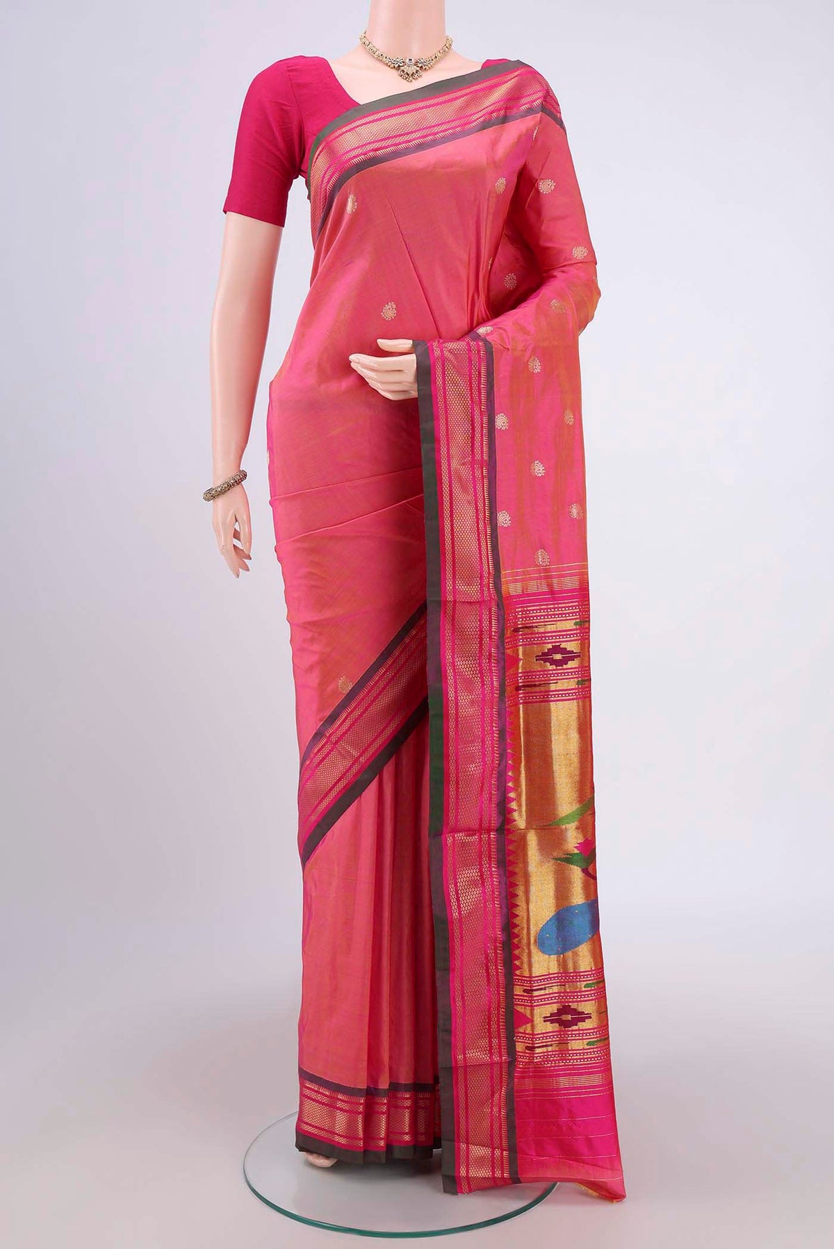 Pinkish Yellow Soft Silk Saree with Zari Butta on the body and Zari Border.  displayed on a mannequin