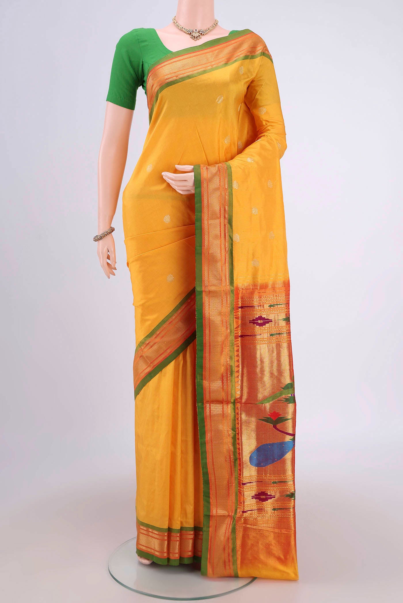 Yellow Soft Silk Saree with Zari Butta on the body and Zari Border.  displayed on a mannequin