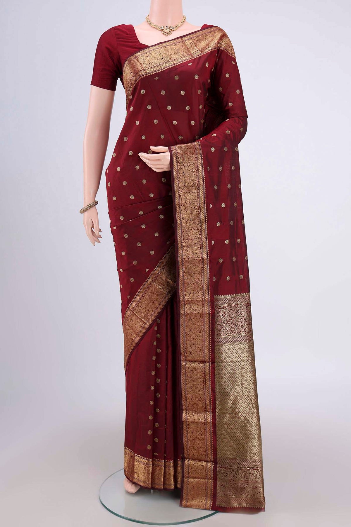 Maroon Blended Bangalore Silk Saree with Zari Butta on the body and Zari Border.  displayed on a mannequin