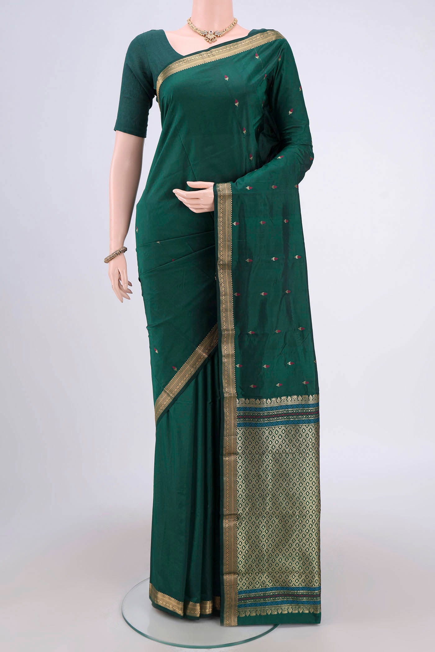 Bottle Green Blended Bangalore Silk Saree with Zari And Thread Butta on the body and Zari Border.  displayed on a mannequin