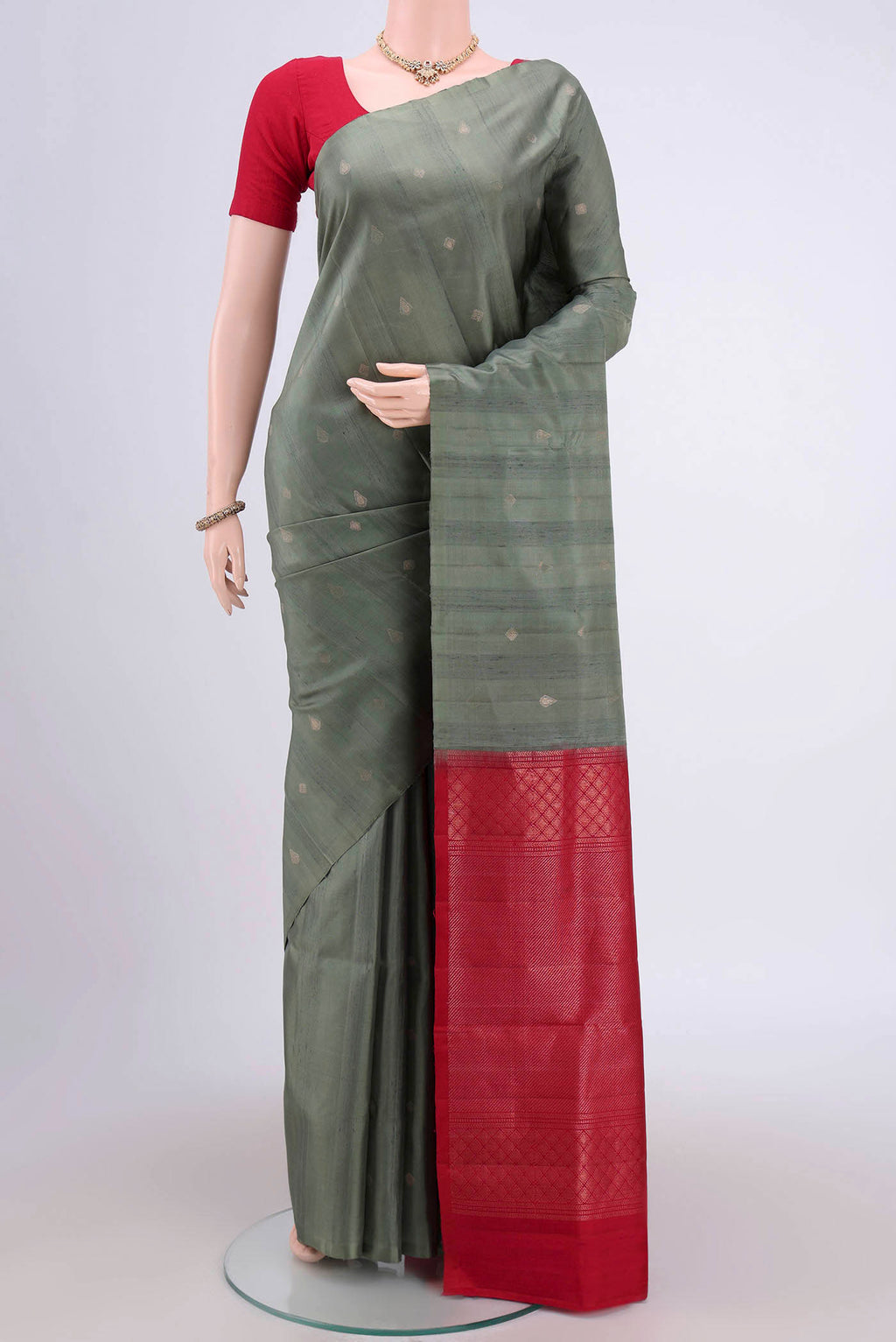 Pista Green Soft Silk Saree with Zari Butta on the body and Zari Border.  displayed on a mannequin