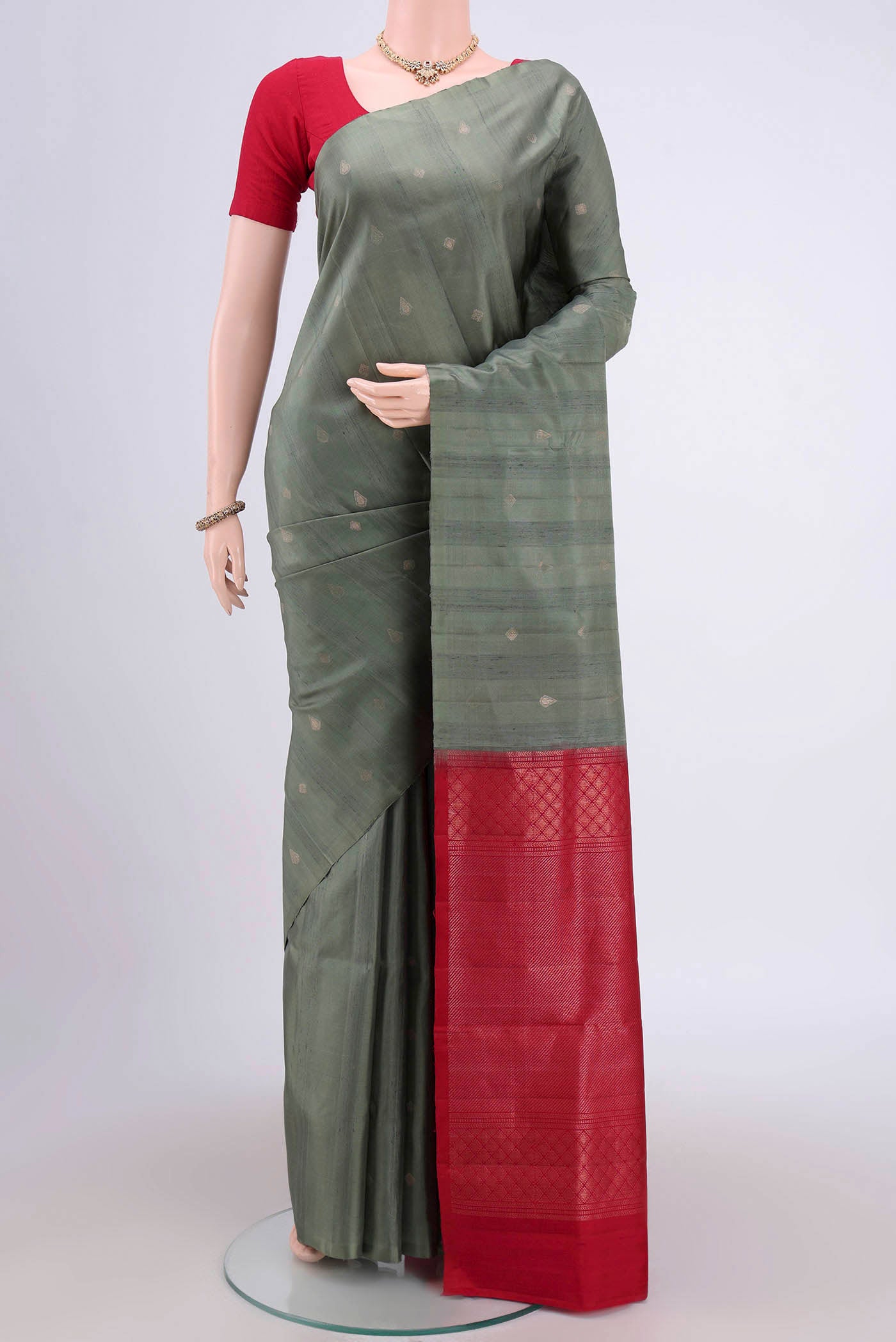Pista Green Soft Silk Saree with Zari Butta on the body and Zari Border.  displayed on a mannequin