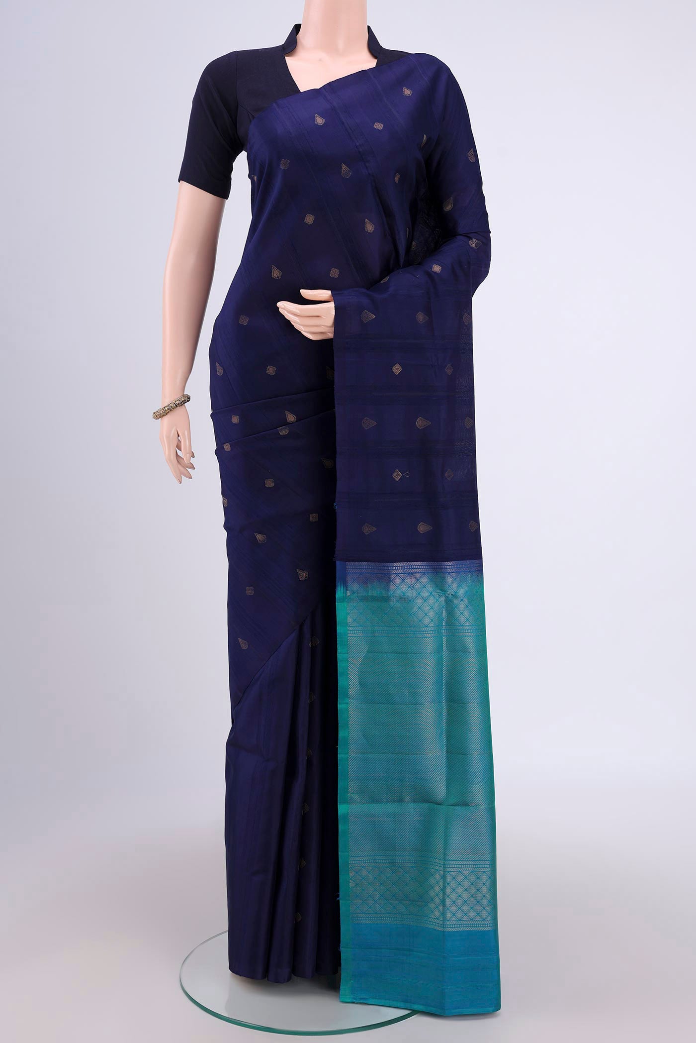 Navy Blue Soft Silk Saree with Zari Butta on the body and Zari Border.  displayed on a mannequin