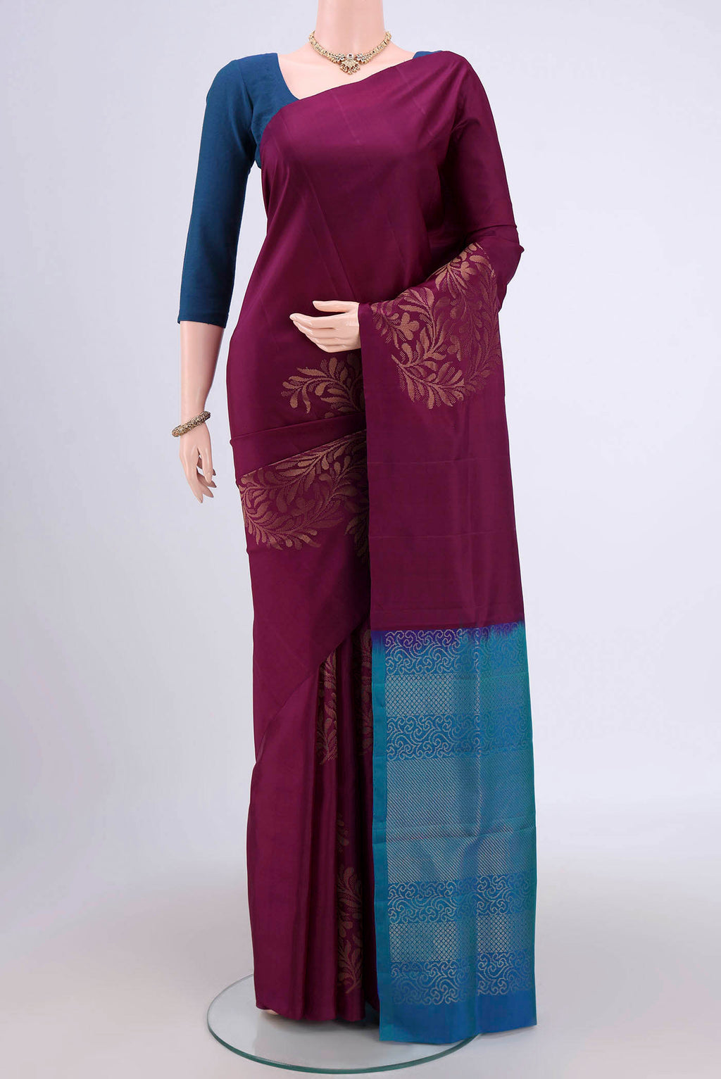 Burgundy Soft Silk Saree with Zari Butta on the body and Zari Border.  displayed on a mannequin
