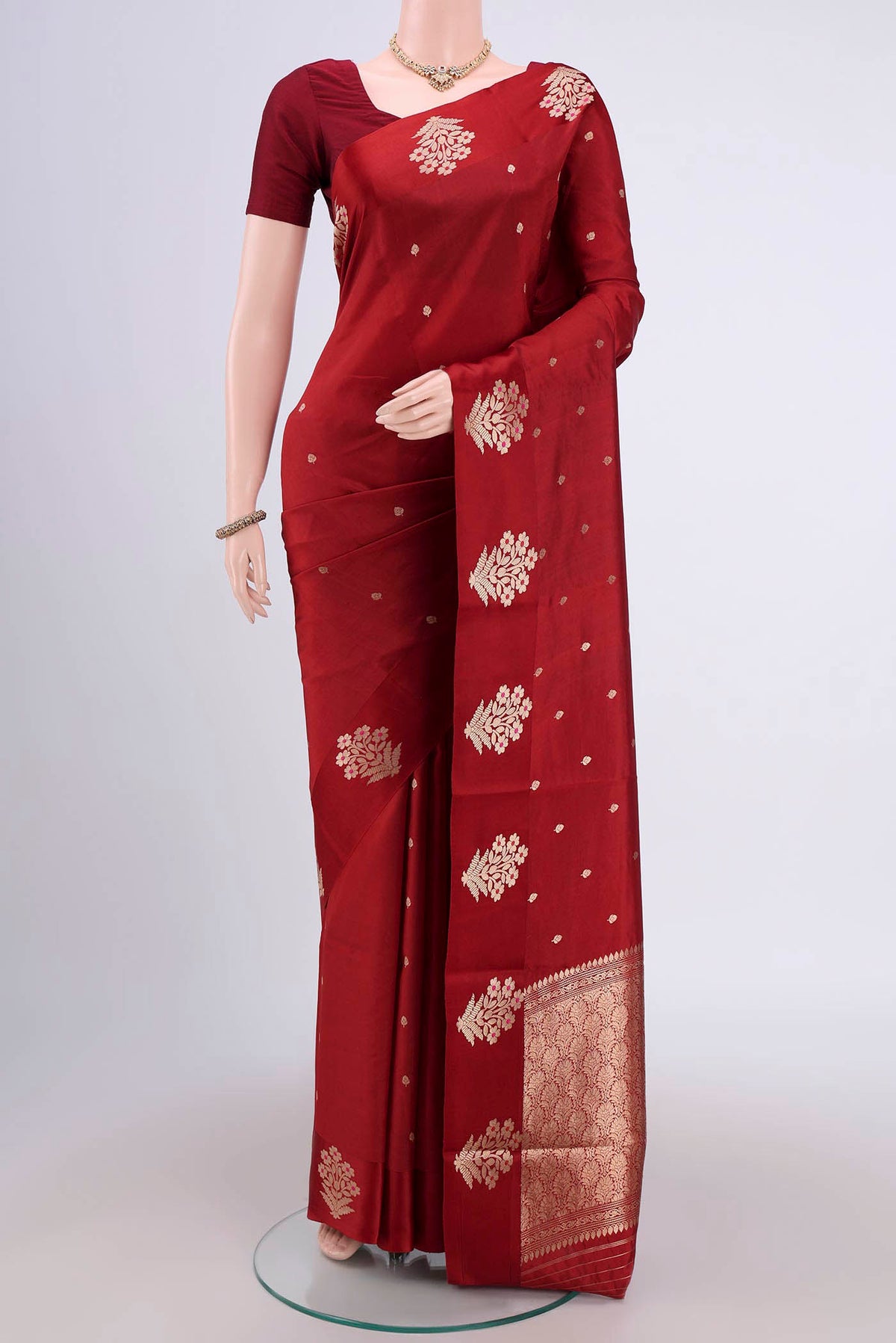 Maroon Banarasi Katan Silk Saree with Zari Butta on the body and Zari Border.  displayed on a mannequin