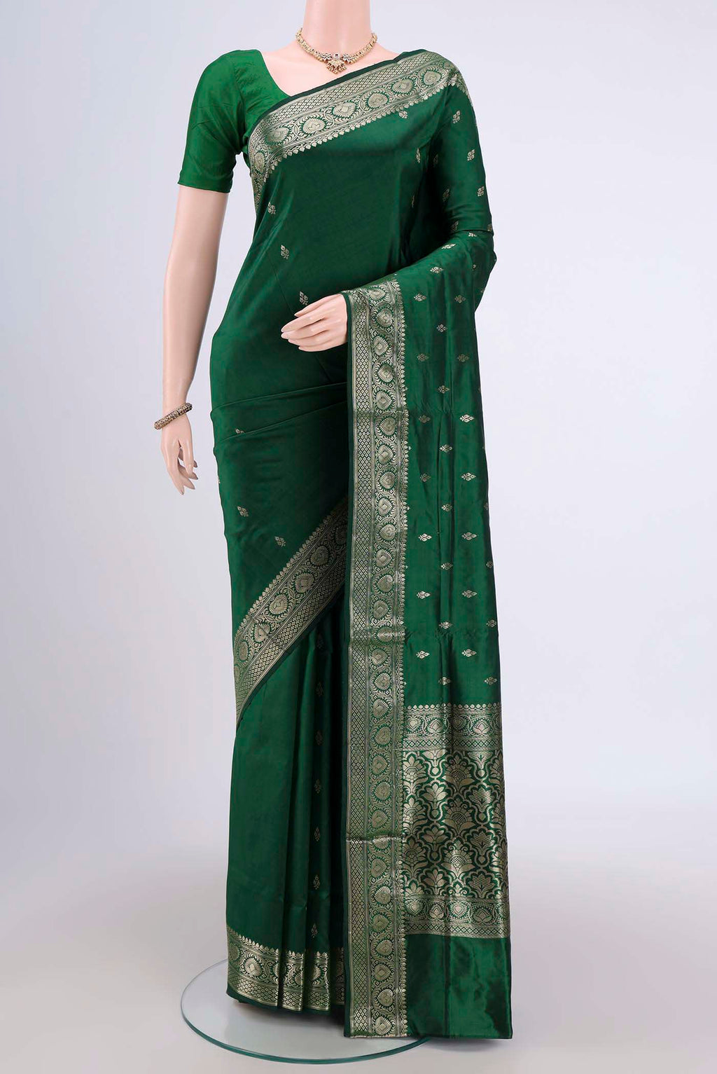 Bottle Green Banarasi Katan Silk Saree with Zari Butta on the body and Zari Border.  displayed on a mannequin