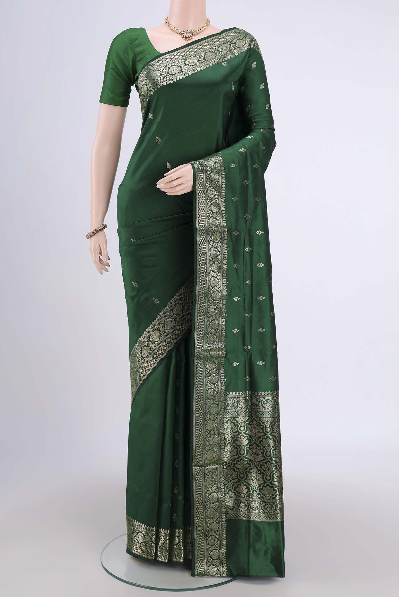 Bottle Green Banarasi Katan Silk Saree with Zari Butta on the body and Zari Border.  displayed on a mannequin