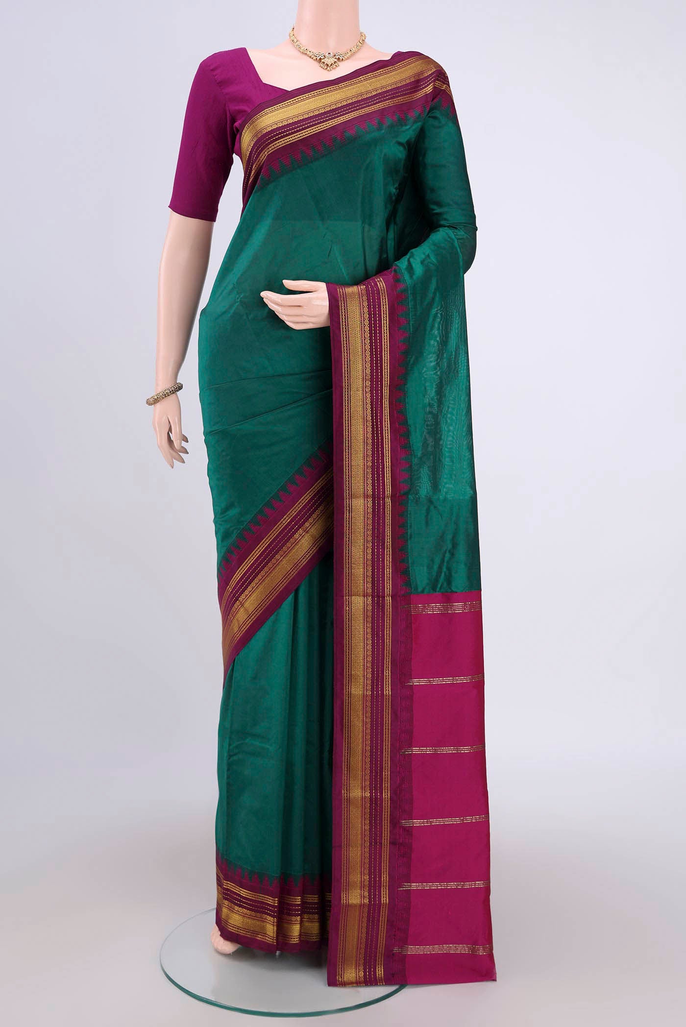 Bottle Green Bangalore Silk Saree with Plain Body and Zari Border.  displayed on a mannequin