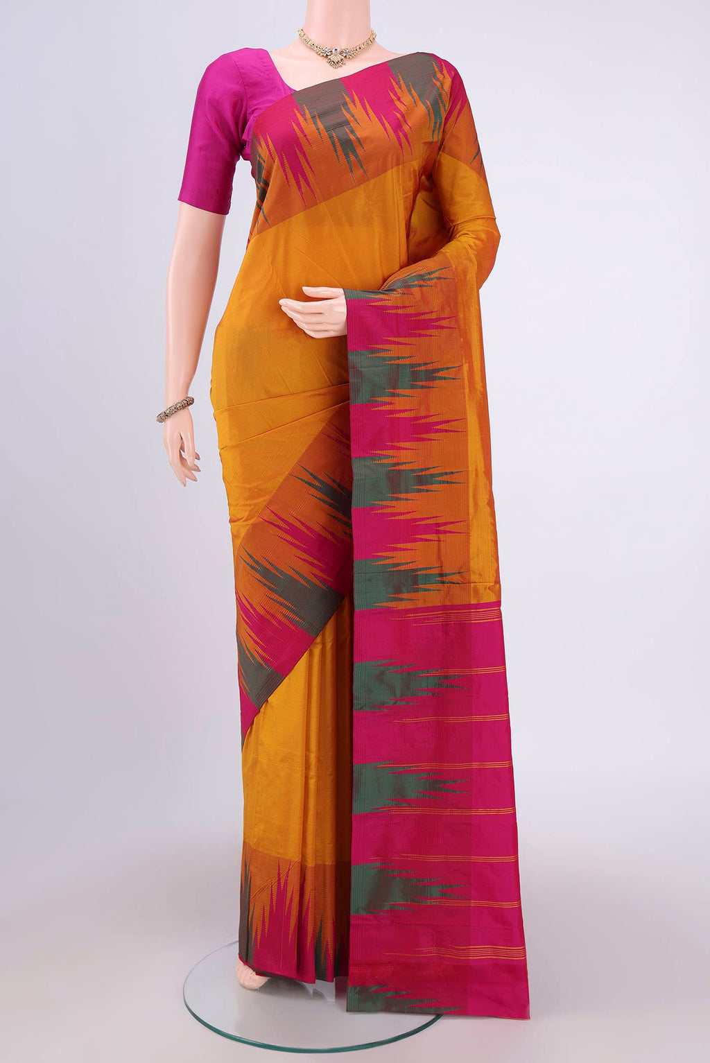 Mustard Bangalore Silk Saree with Plain Body and Temple Border.  displayed on a mannequin