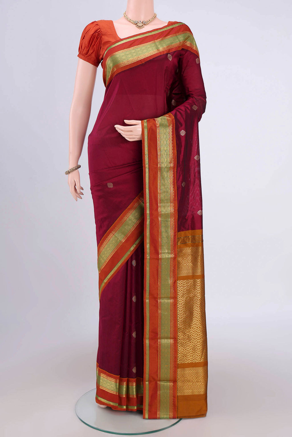 Maroon Bangalore Silk Saree with Zari Butta on the body and Zari Border.  displayed on a mannequin