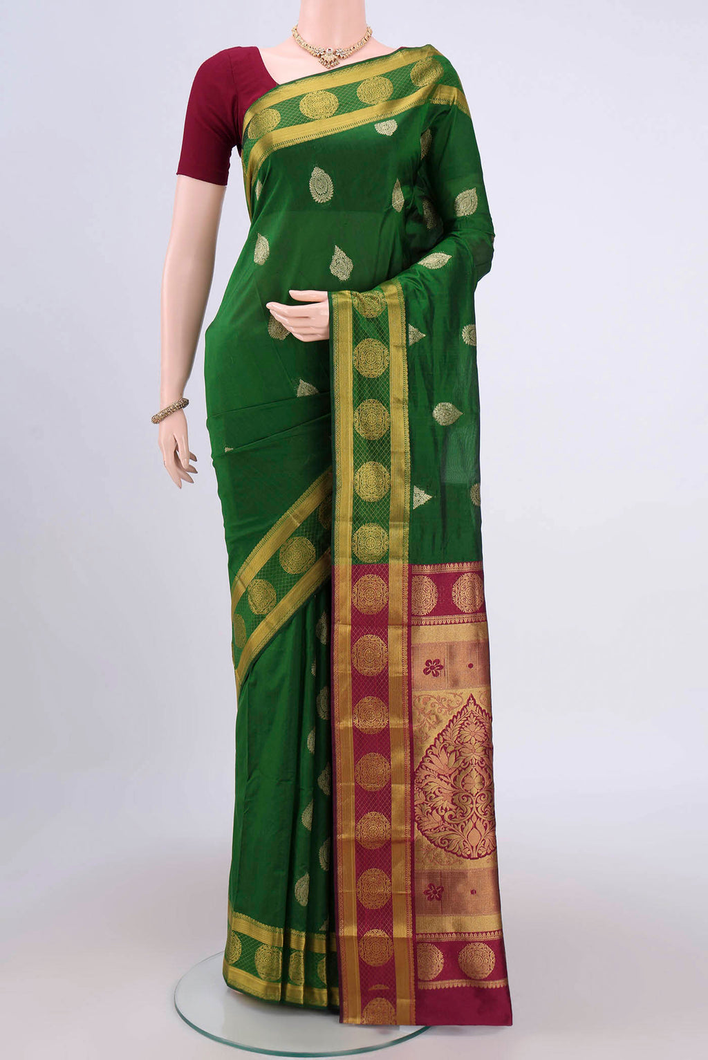 Bottle Green Bangalore Silk Saree with Zari Butta on the body and Zari Border.  displayed on a mannequin