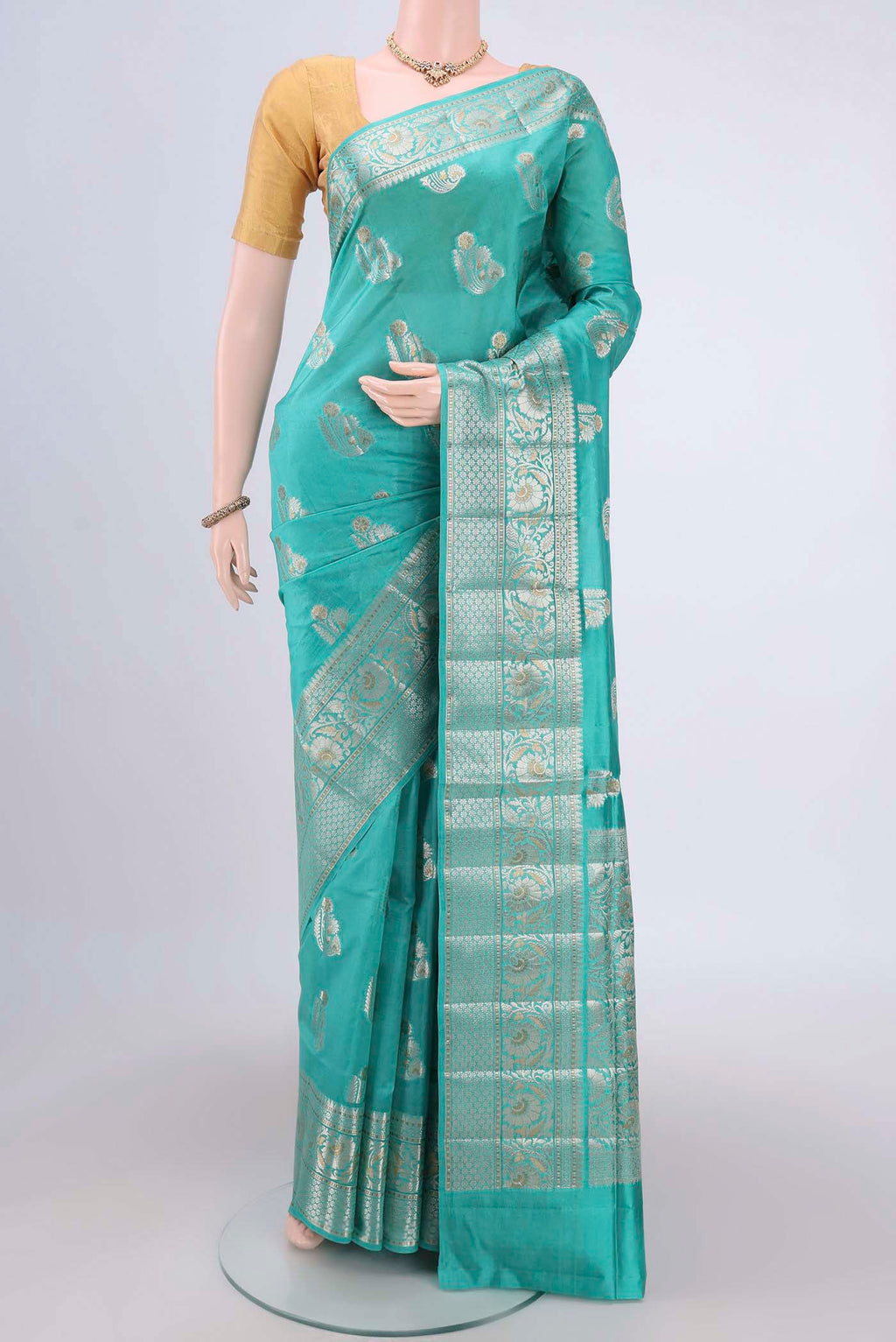 Turquoise Banarasi Raw Silk Saree with Zari Butta on the body and Zari Border.  displayed on a mannequin