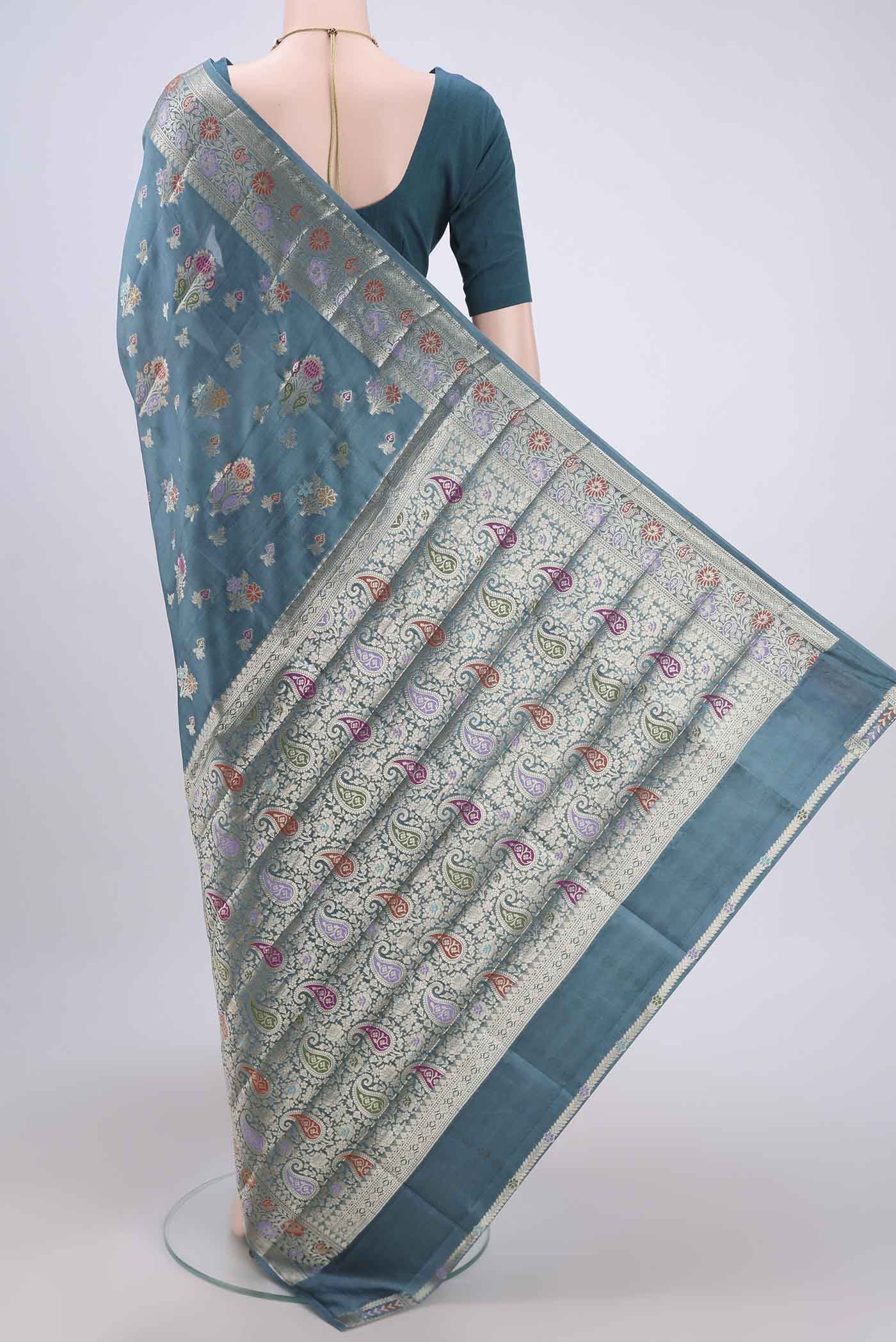 Flat view of Blue Grey Banarasi Raw Silk Saree with Zari Butta on the body and Zari Border. 