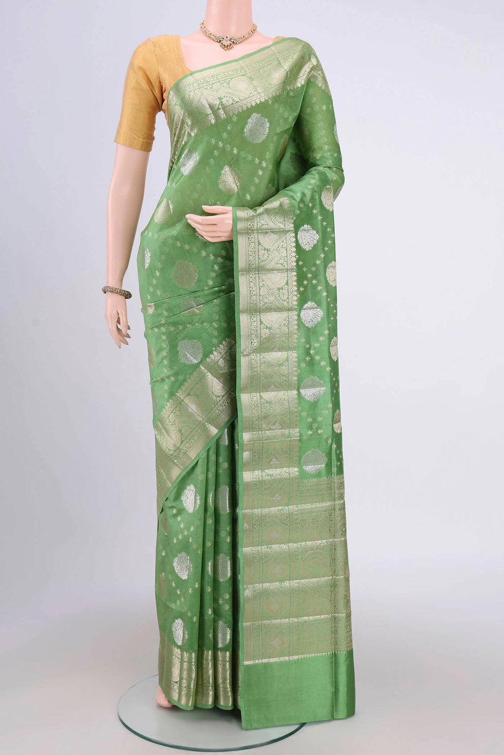 Light Green Banarasi Raw Silk Saree with Zari Butta on the body and Zari Border.  displayed on a mannequin