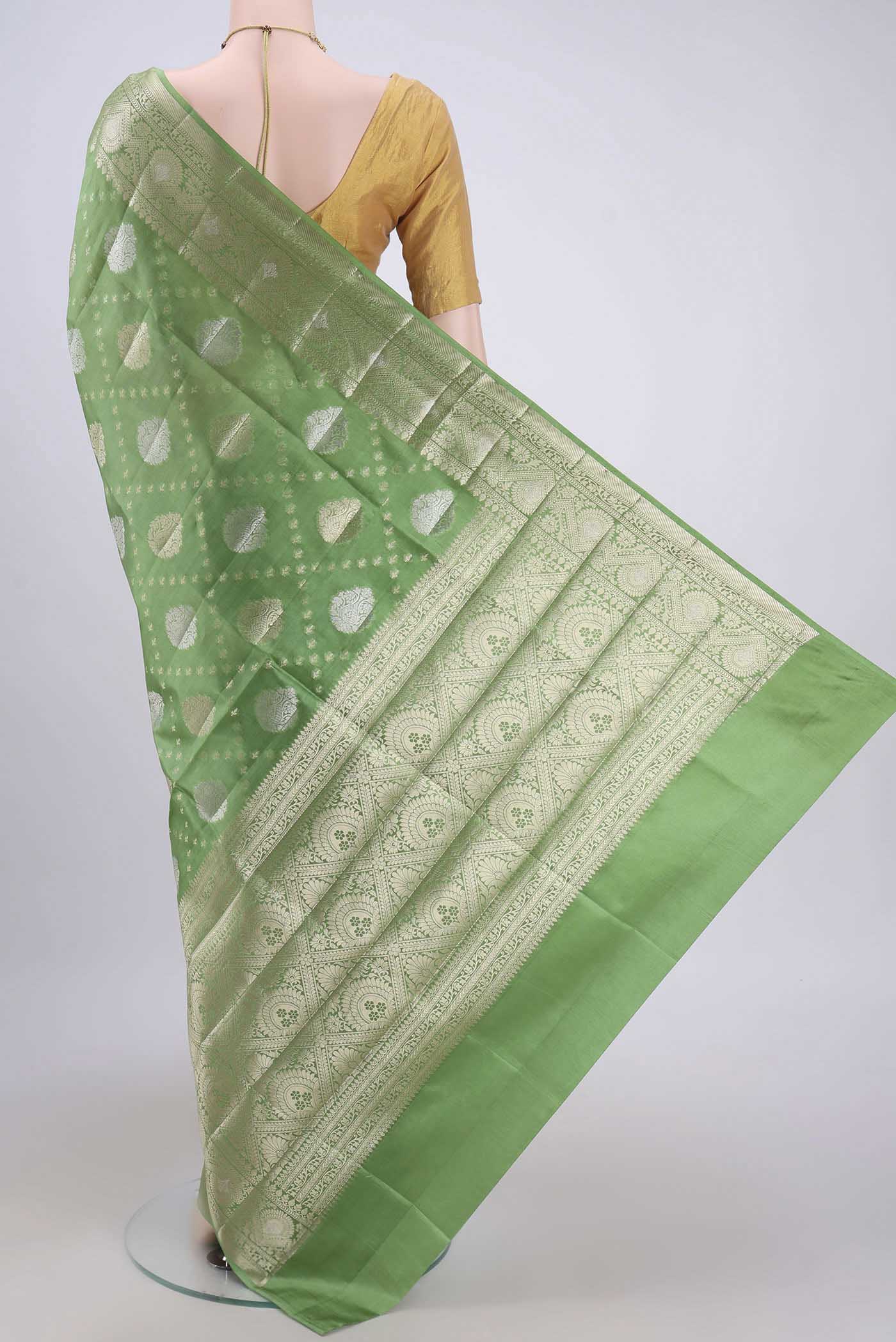 Flat view of Light Green Banarasi Raw Silk Saree with Zari Butta on the body and Zari Border. 