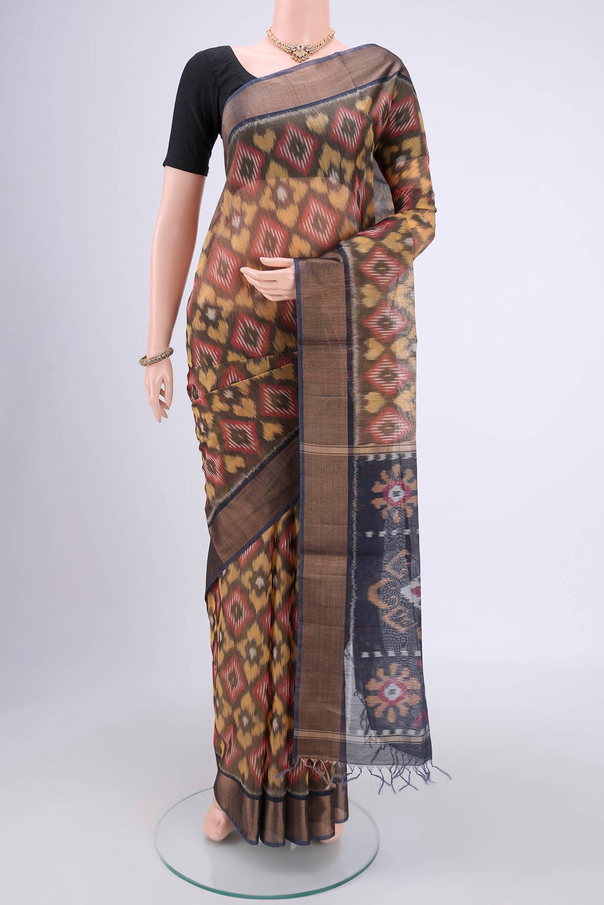 Yellow Silk Cotton Saree with Ikat design on the body and Zari Border.  displayed on a mannequin