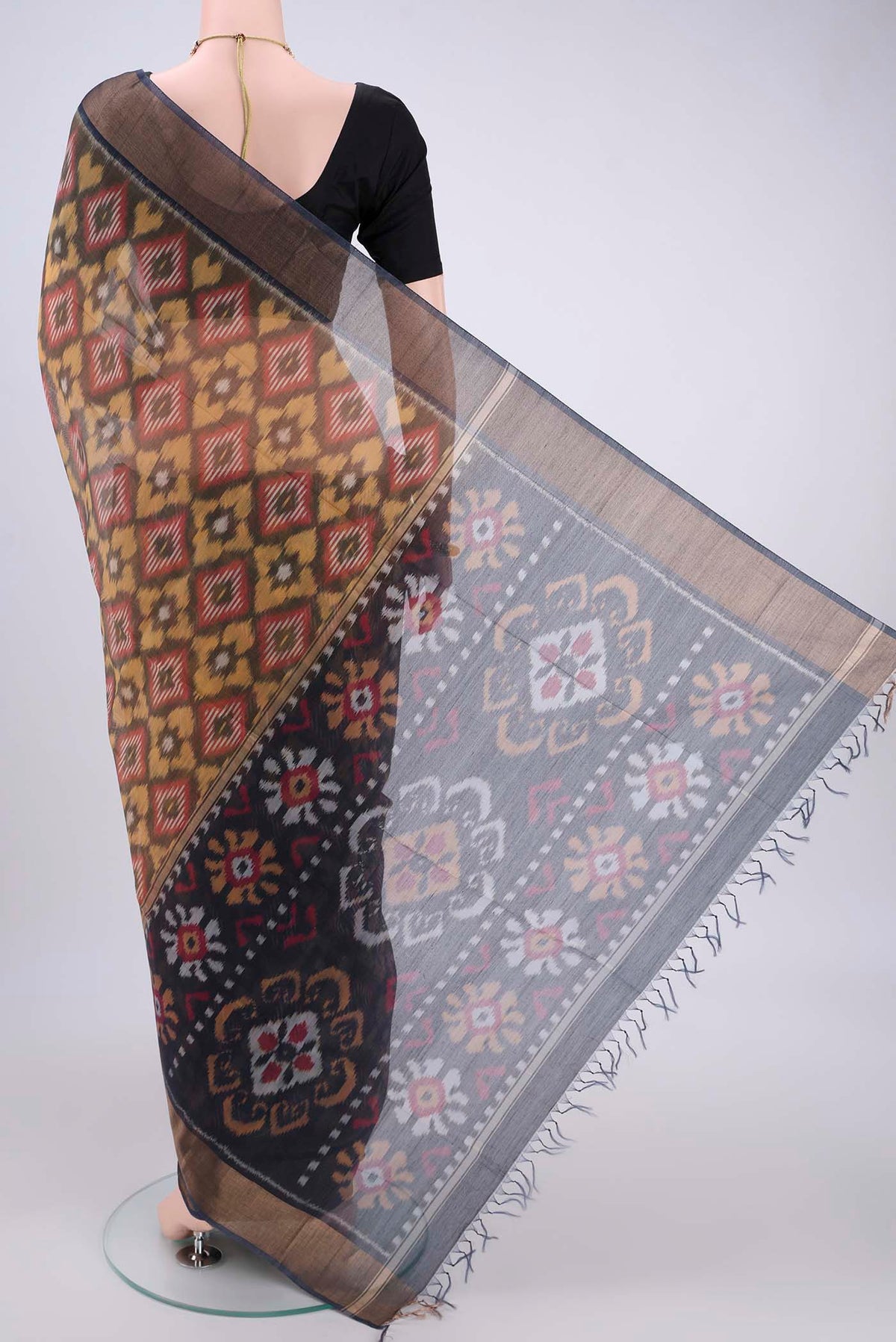 Flat view of Yellow Silk Cotton Saree with Ikat design on the body and Zari Border. 