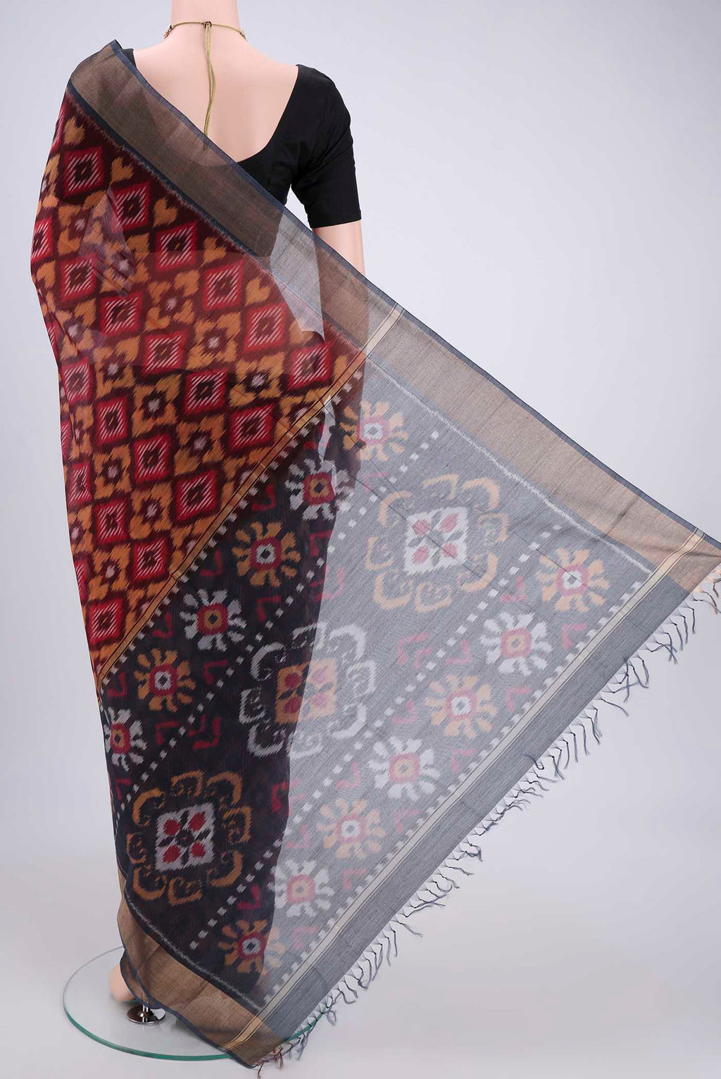 Flat view of Maroon Silk Cotton Saree with Ikat design on the body and Zari Border. 