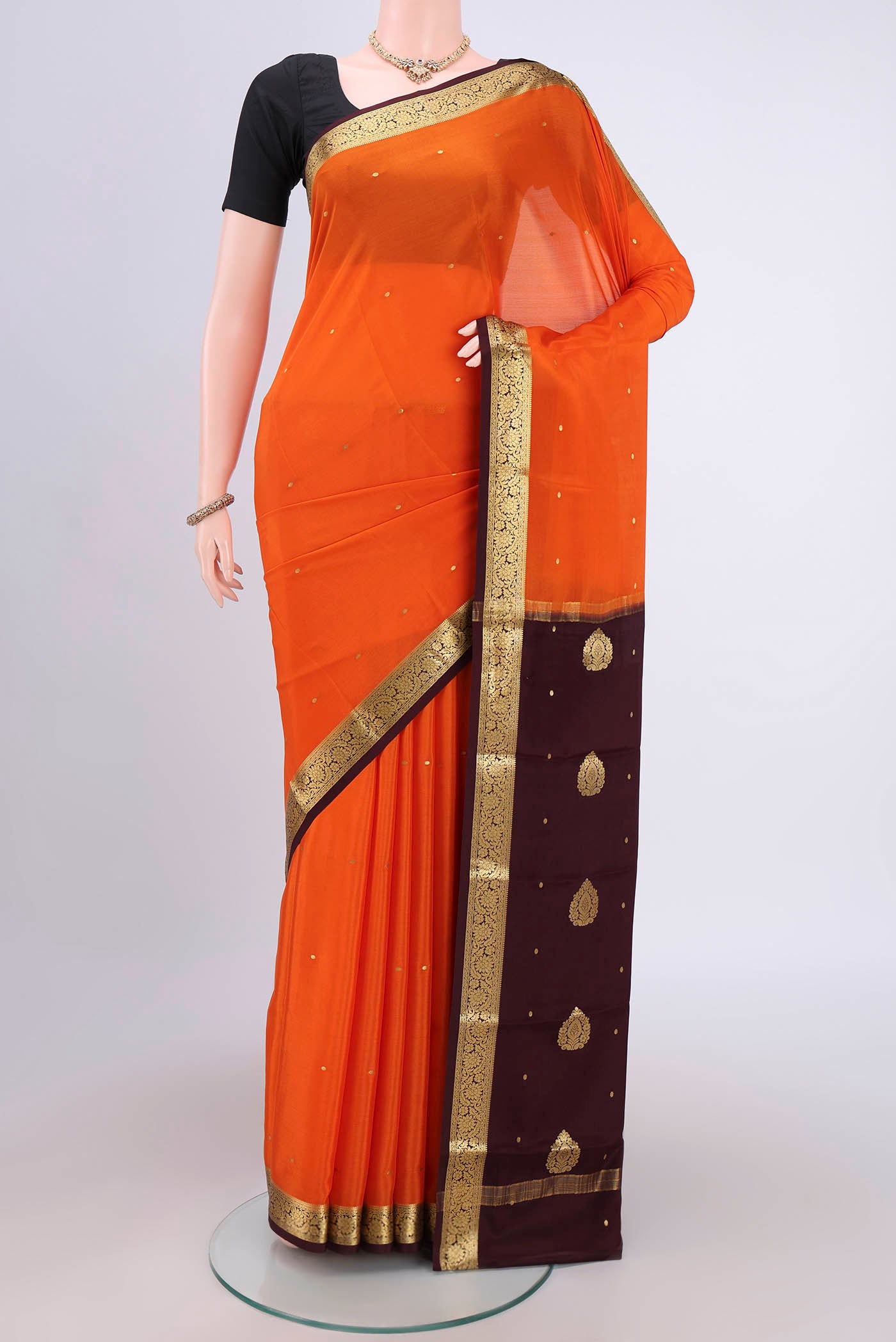 Orange Mysore Crepe Saree with Zari Butta on the body and Zari Border.  displayed on a mannequin
