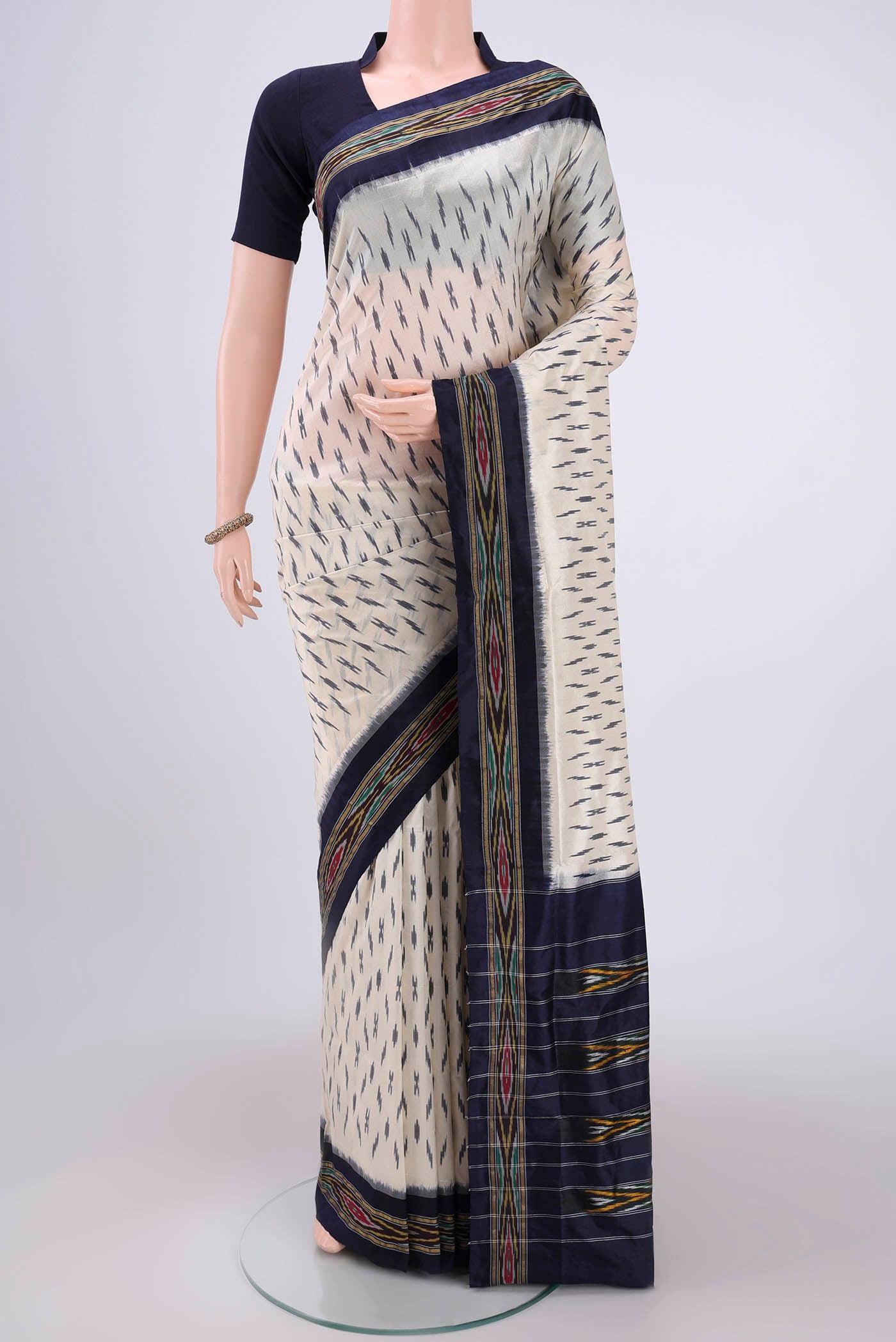 Off White Pochampally Silk Saree with Ikat design on the body and Ikat Border.  displayed on a mannequin