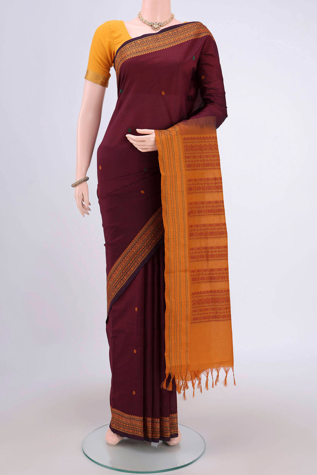 Maroon Blended Poly Cotton Saree with Thread Butta on the body and Thread Border.  displayed on a mannequin