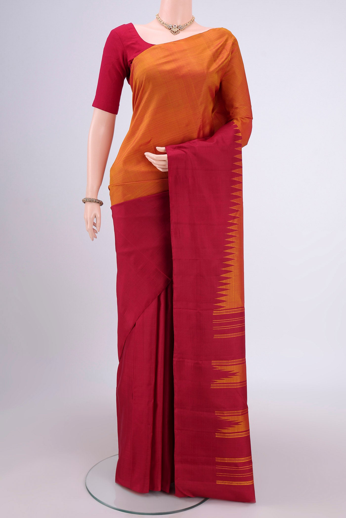 Mustard Kanchipuram Silk Saree with Plain Body and Rising Temple Border.  displayed on a mannequin