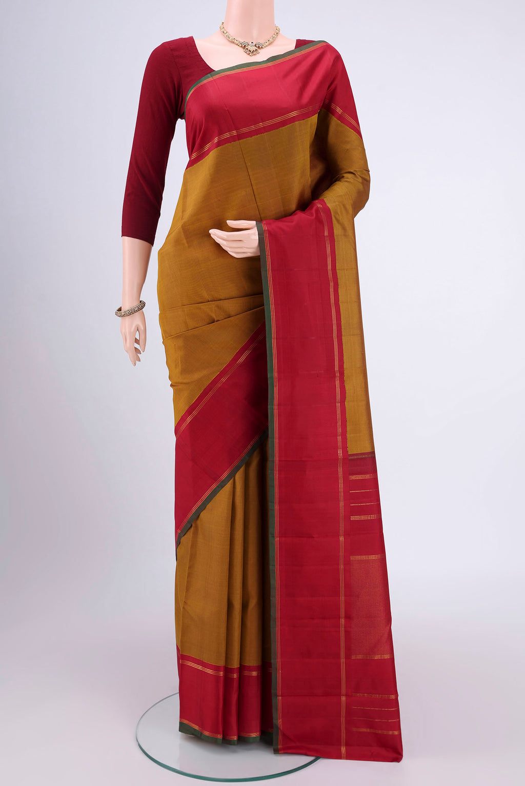 Golden Kanchipuram Silk Saree with Plain Body and Zari Border.  displayed on a mannequin
