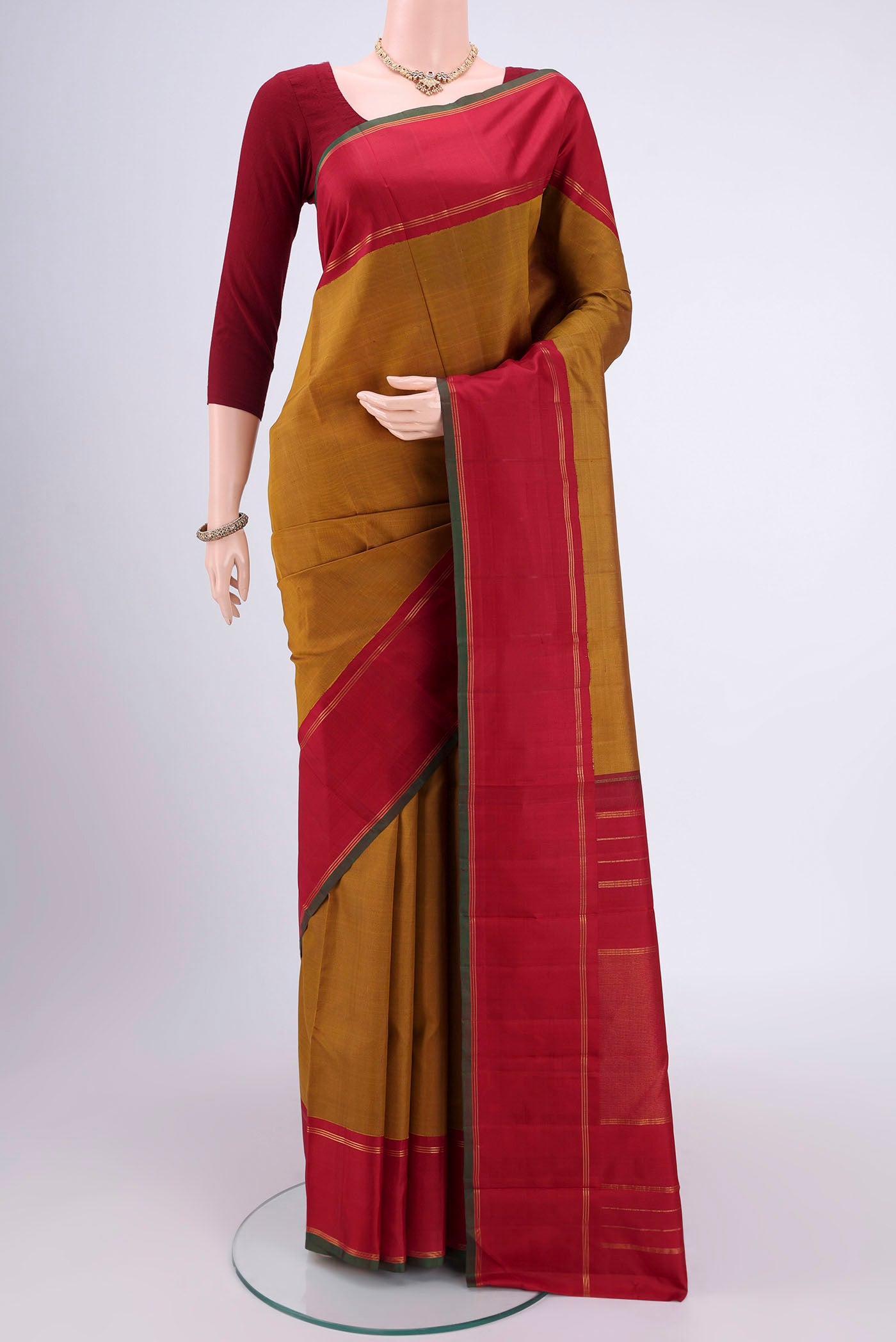 Golden Kanchipuram Silk Saree with Plain Body and Zari Border.  displayed on a mannequin