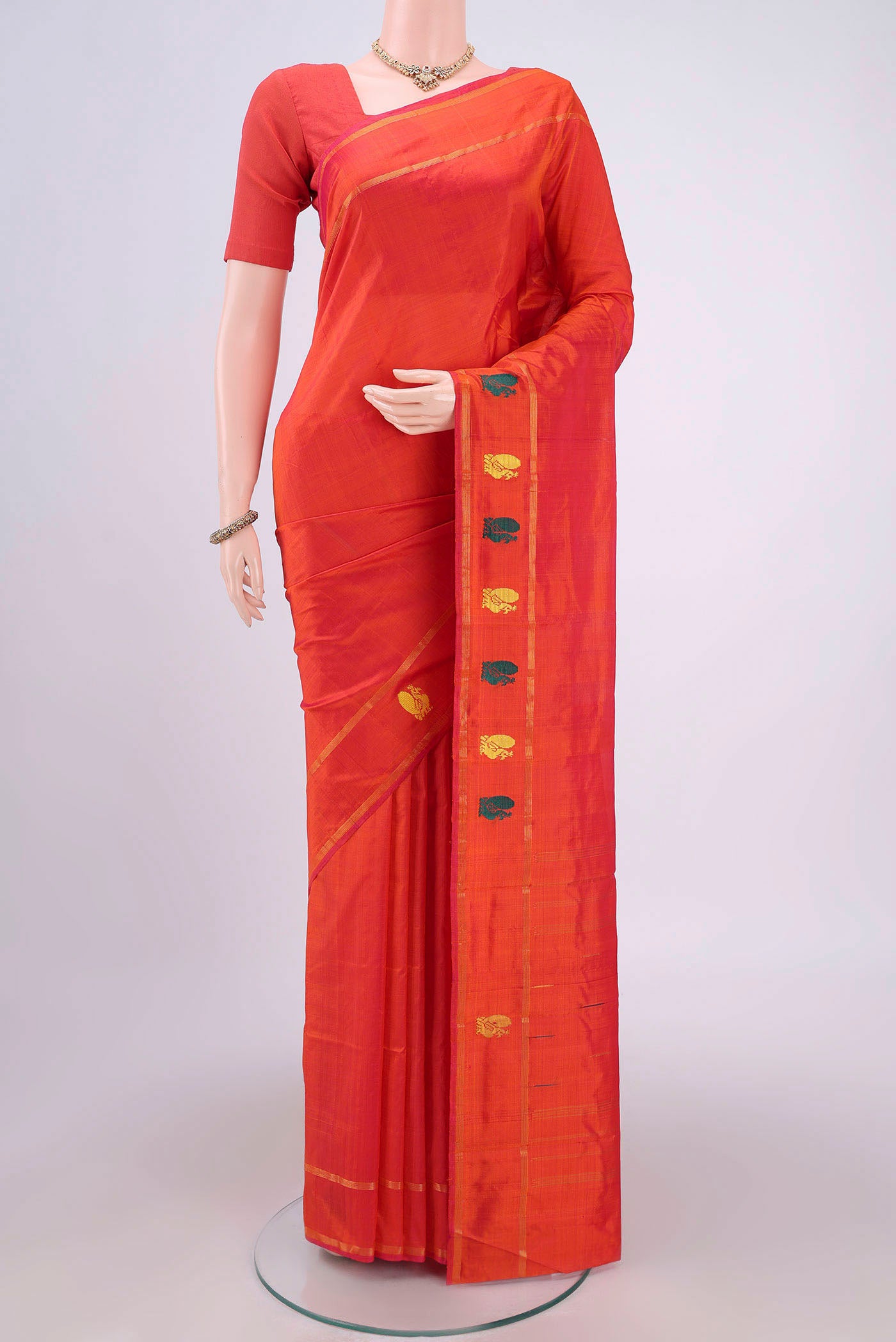 Brick Orange Kanchipuram Silk Saree with Plain Body and Zari And Thread Border.  displayed on a mannequin