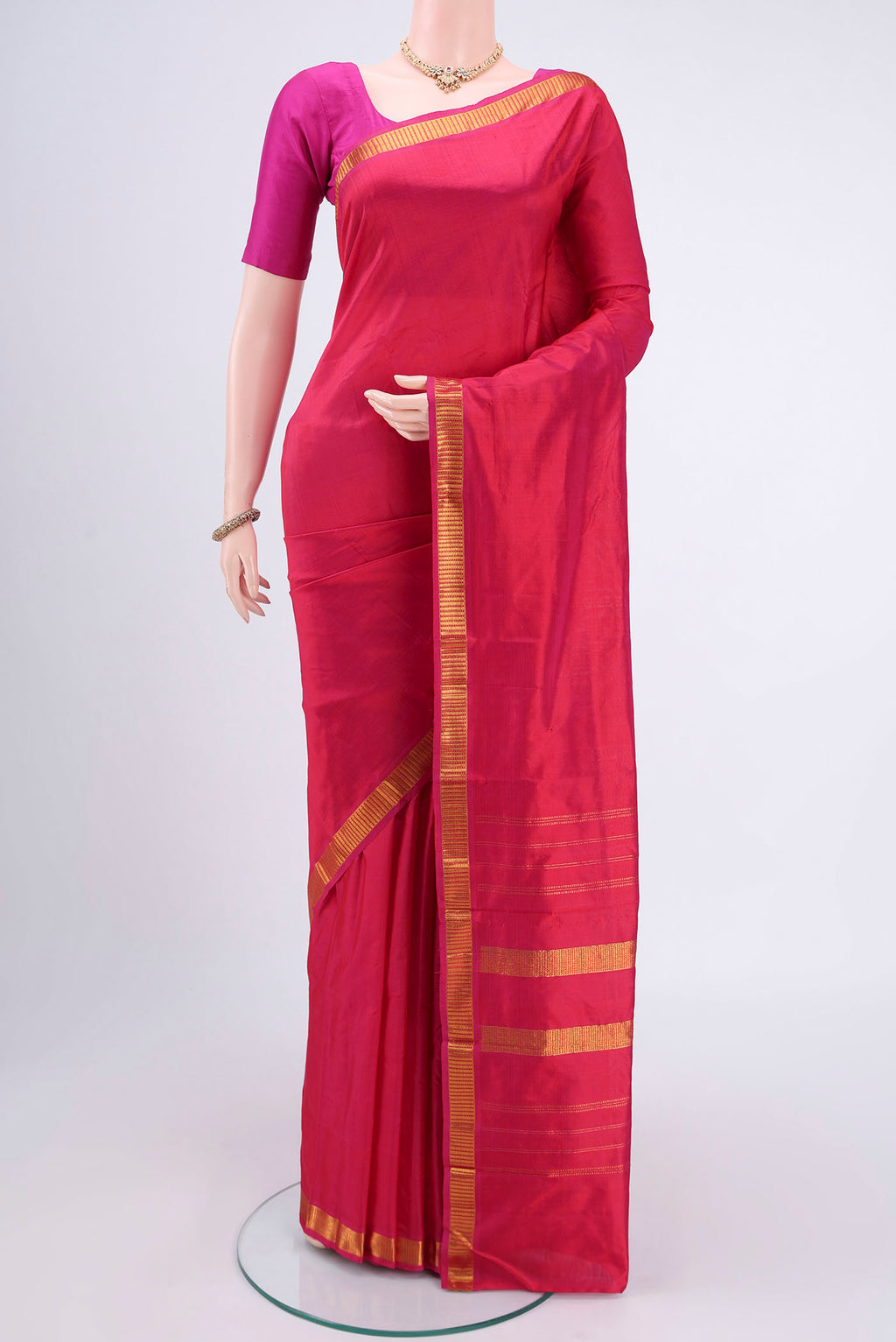 Dark Pink Kanchipuram Silk Saree with Plain Body and Zari Border.  displayed on a mannequin