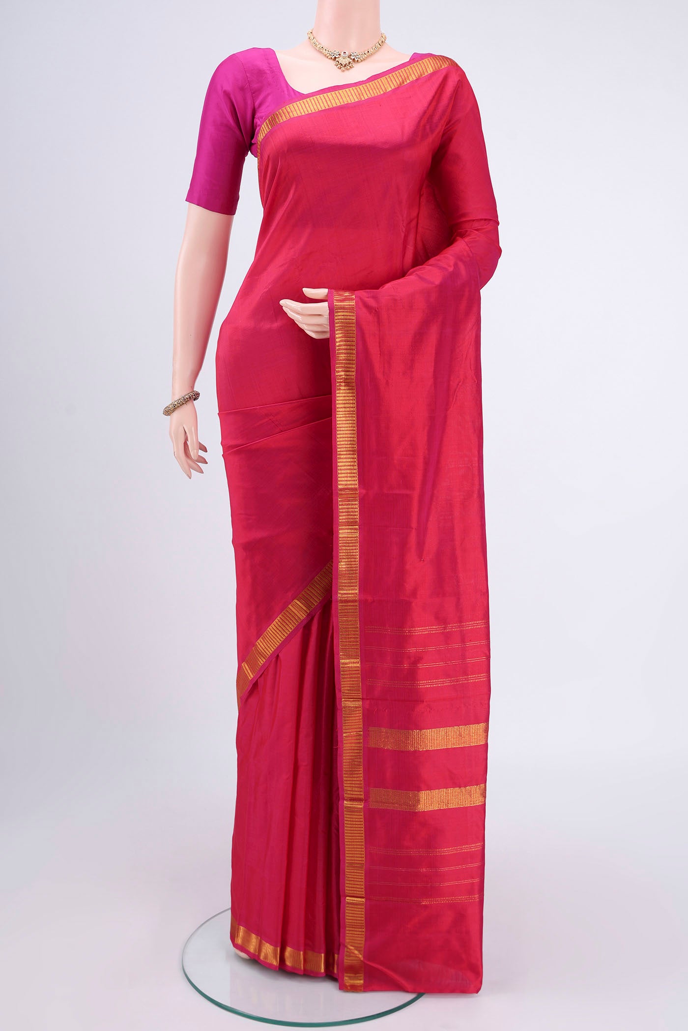 Dark Pink Kanchipuram Silk Saree with Plain Body and Zari Border.  displayed on a mannequin