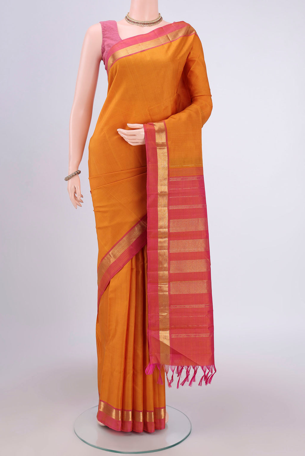 Mustard Kanjivaram Silk Saree with Plain Body and Zari Border.  displayed on a mannequin