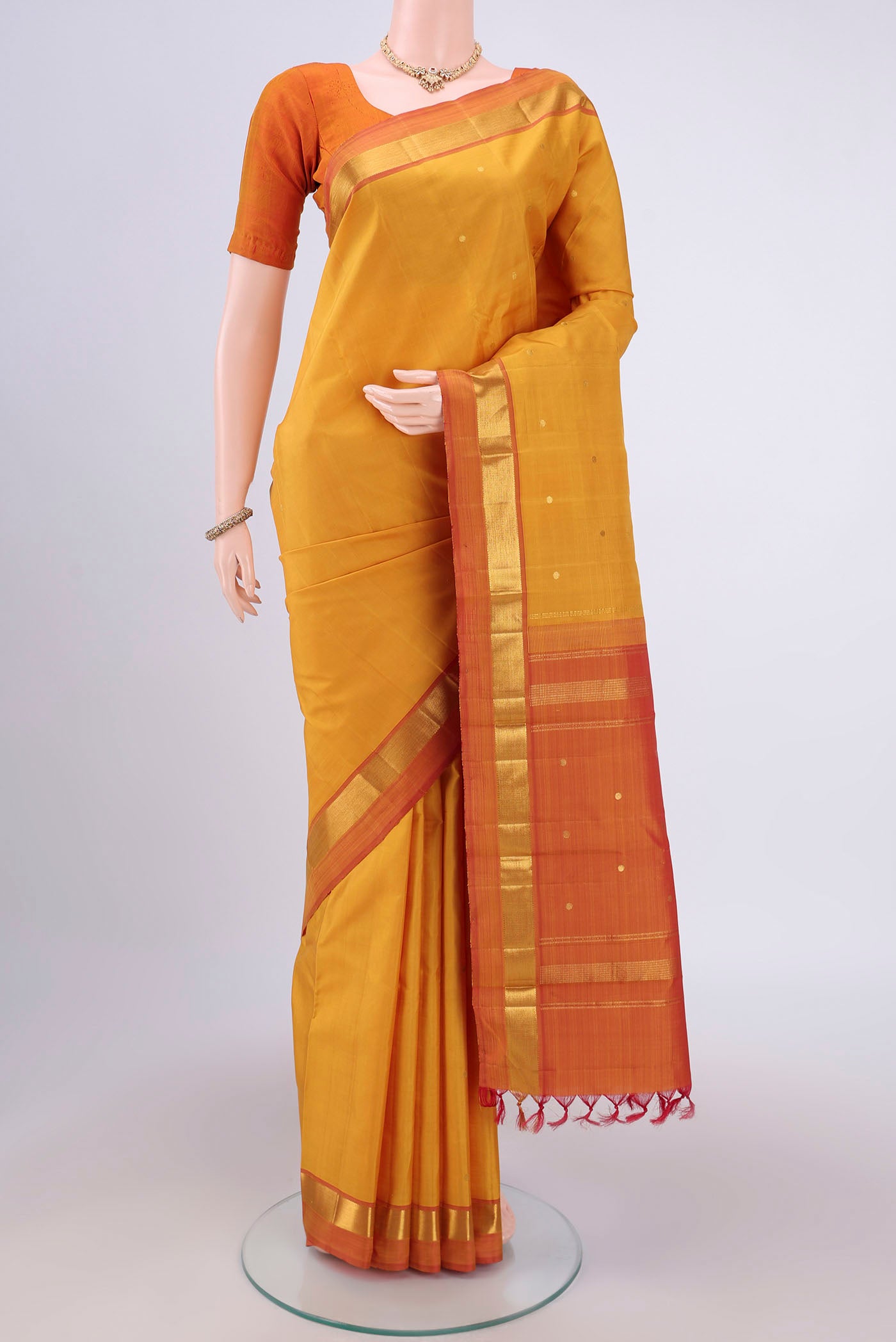 Mustard Dual Tone Kanjivaram Silk Saree with Zari Butta on the body and Zari Border.  displayed on a mannequin
