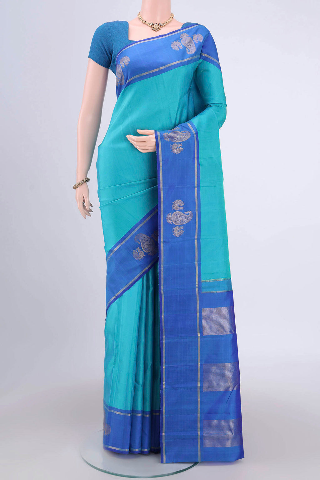 Turquoise Kanchipuram Silk Saree with Plain Body and Zari Border.  displayed on a mannequin