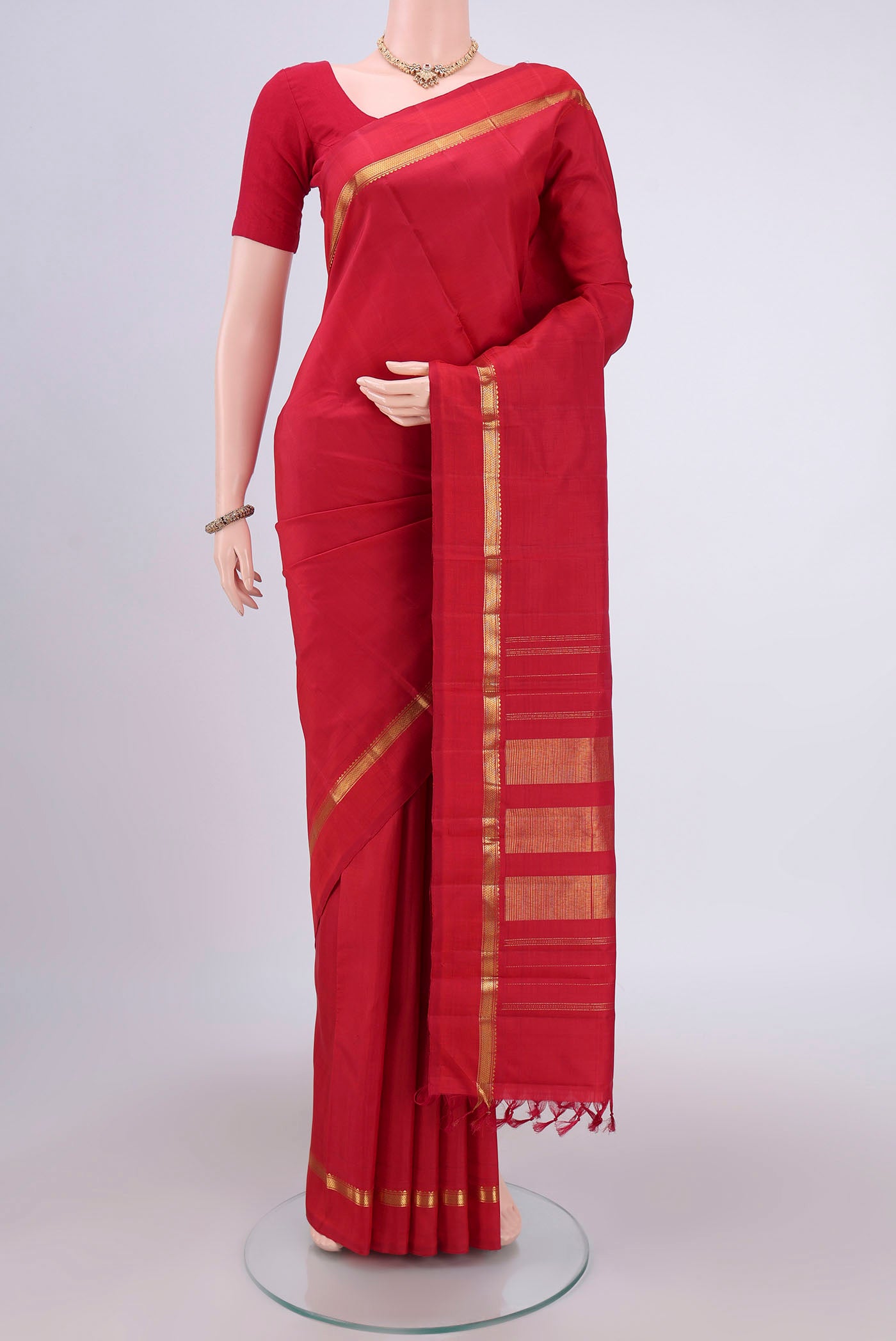 Maroon Kanjivaram Silk Saree with Plain Body and Zari Border.  displayed on a mannequin