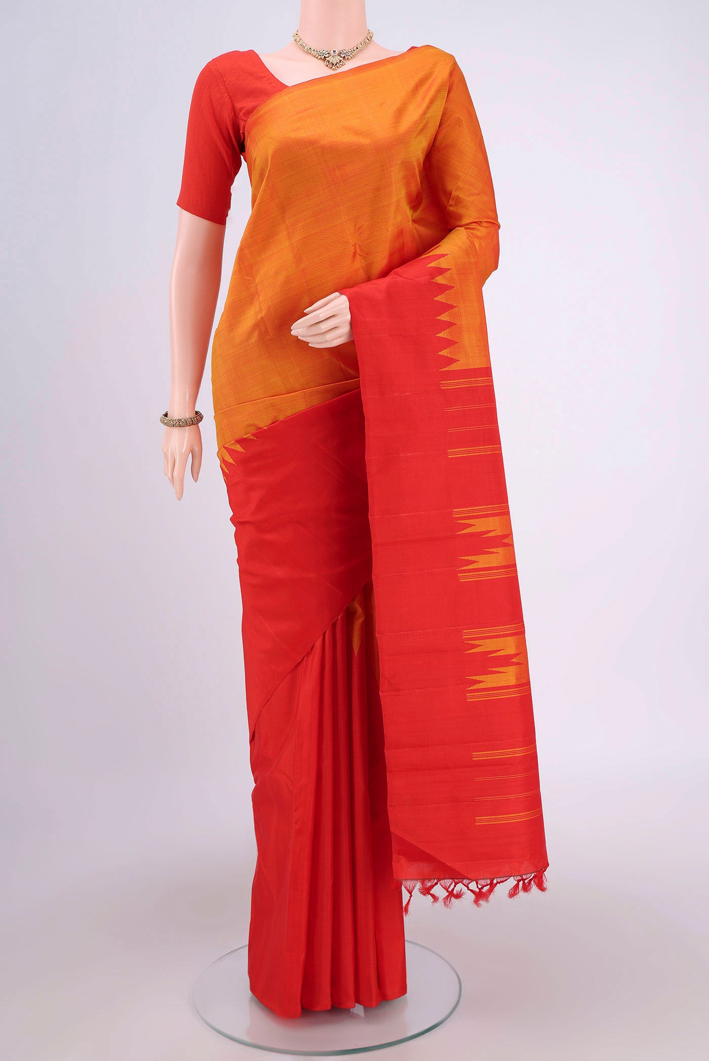 Brick Orange Kanchipuram Saree with Plain Body and Rising Temple Border.  displayed on a mannequin